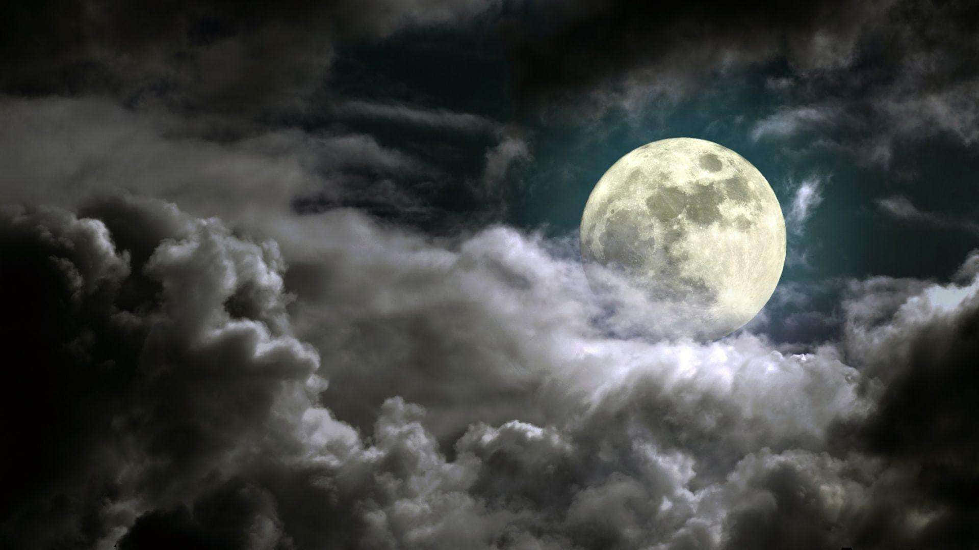雲朵 桌布 壁紙 — 一輪明亮的滿月穿透戲劇性旋轉的暴風雲，在陰鬱的夜空中。