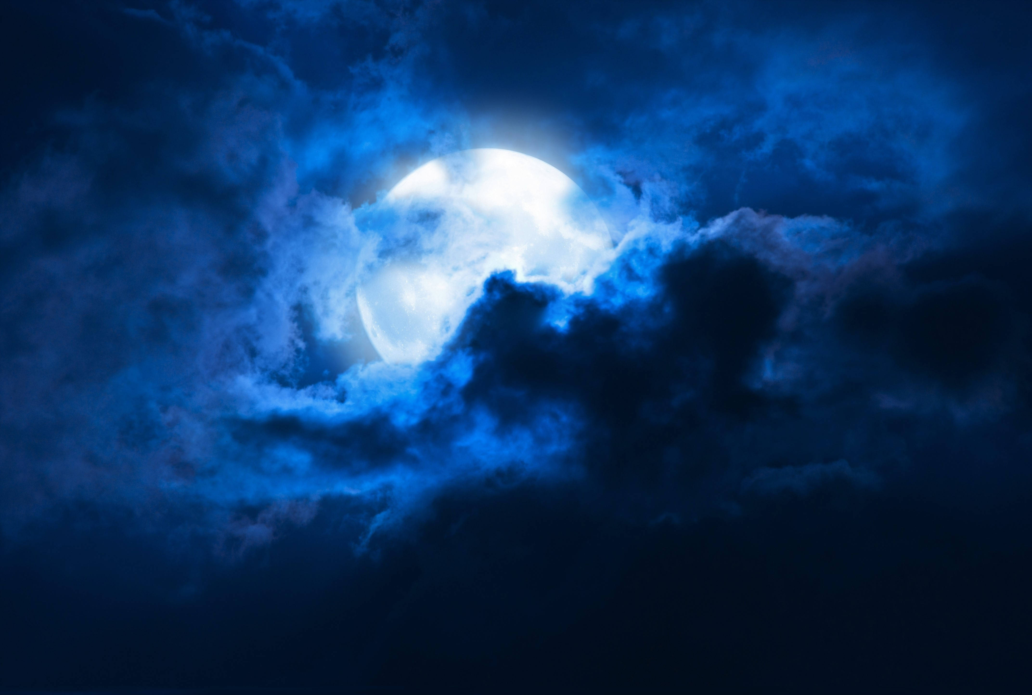 Beautiful Full Moon 桌布 壁紙 — 一輪明亮的滿月穿透旋轉的深藍色雲層，構成戲劇性的夜空。