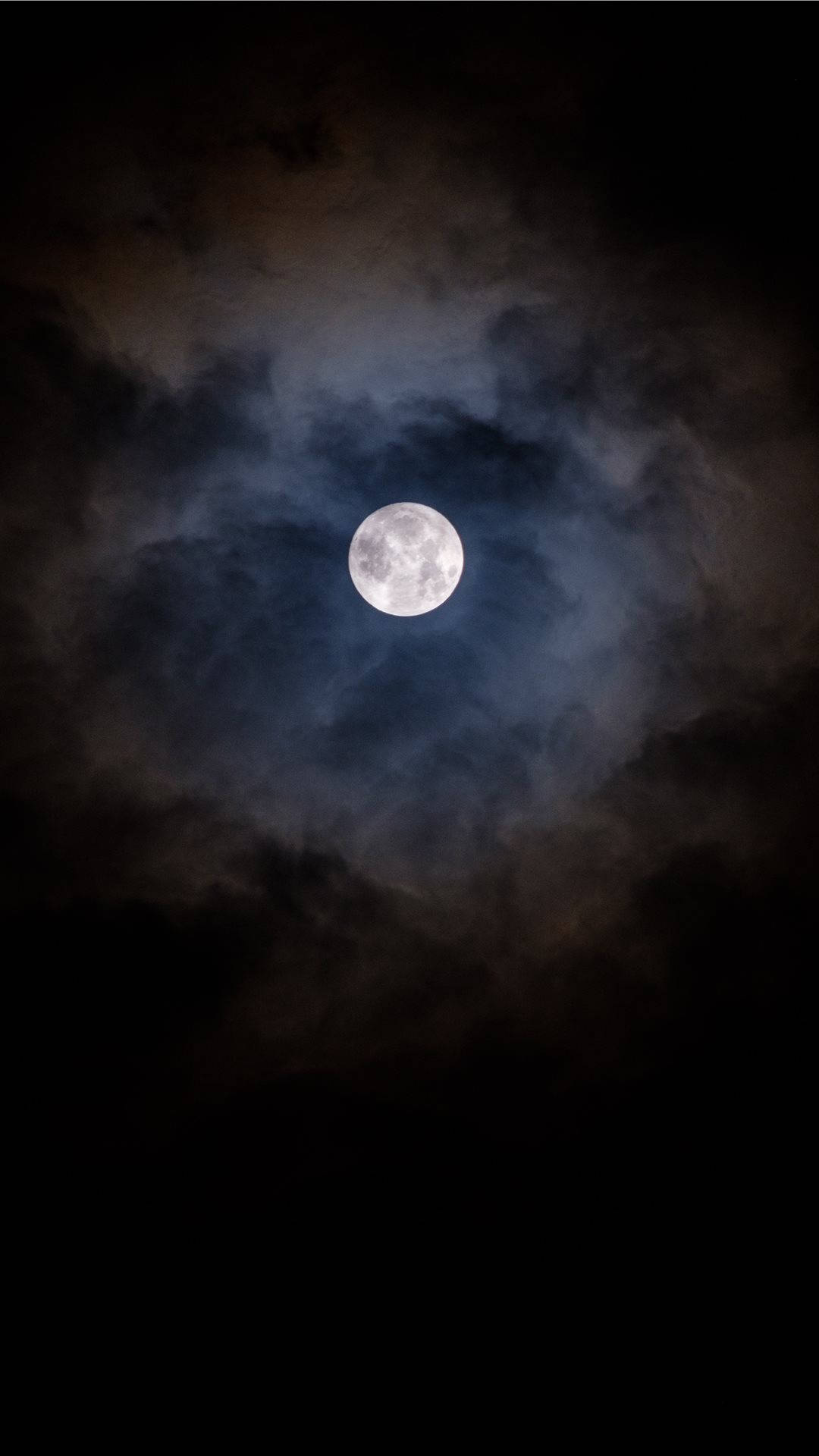 月夜星空 桌布 壁紙 — 一輪明亮的滿月穿透旋轉的烏雲，映照在充滿氛圍的夜空。
