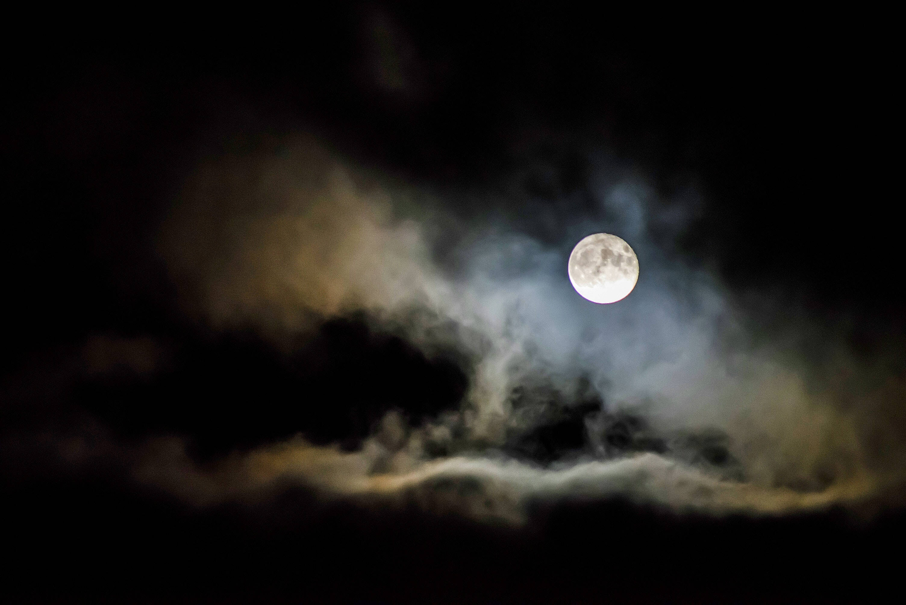 雲朵 桌布 壁紙 — 一輪明亮的滿月穿透翻滾的烏雲，映照在陰鬱的夜空中。
