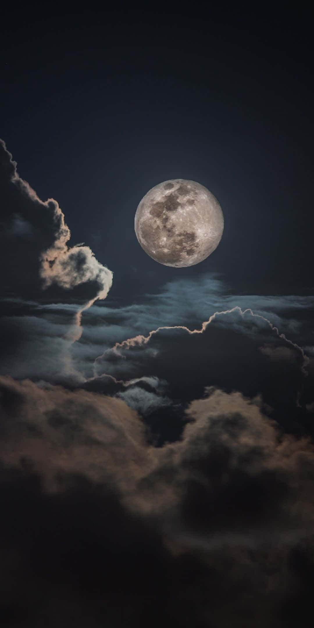 月光 桌布 壁紙 — 一輪明亮的滿月穿過戲劇性的烏雲，在充滿氛圍的夜空中閃耀。