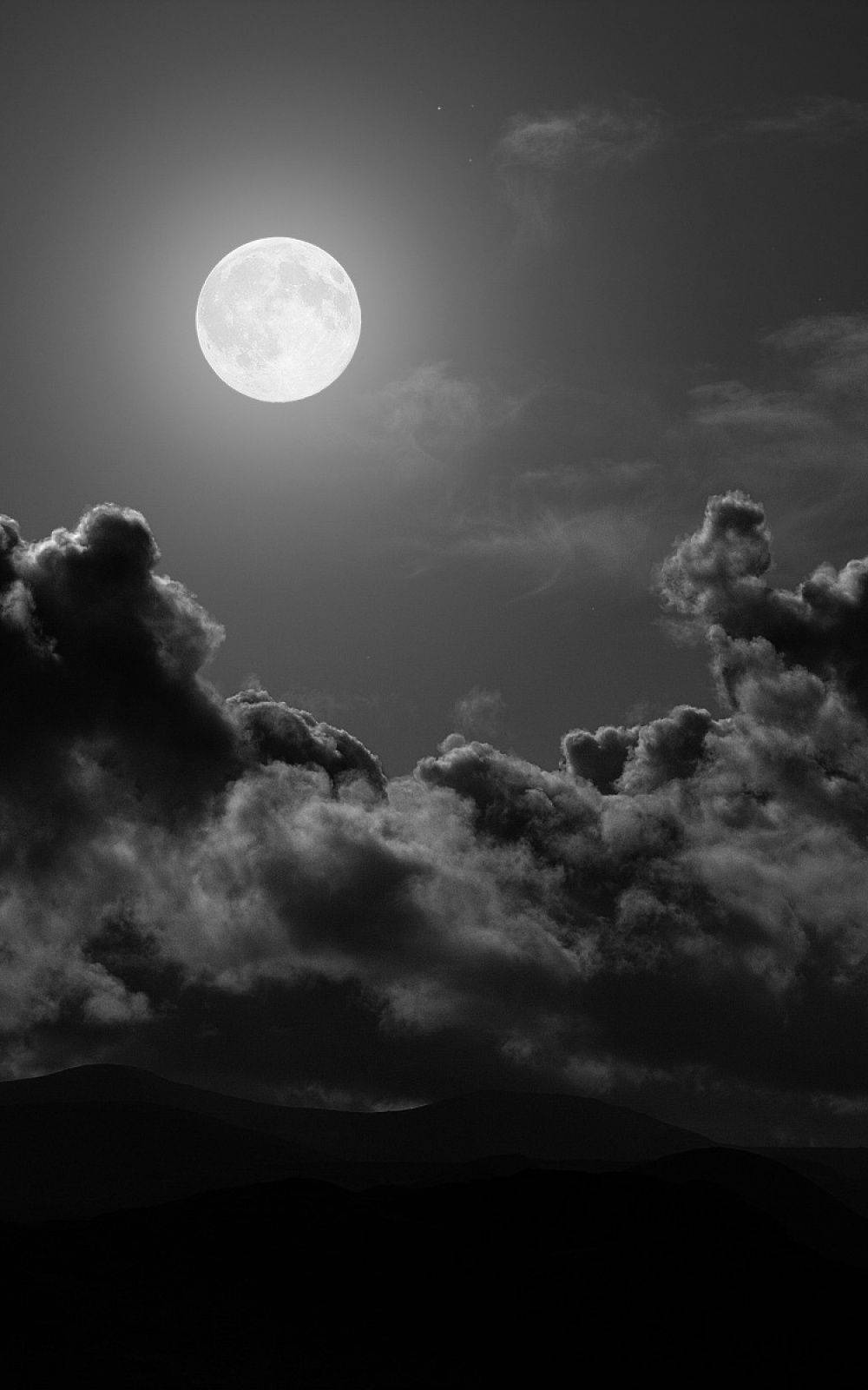 Night Sky Moon 桌布 壁紙 — 一輪明亮的滿月穿過戲劇性的雲層，照耀在剪影般的山脈之上，呈現出鮮明的黑白夜空。
