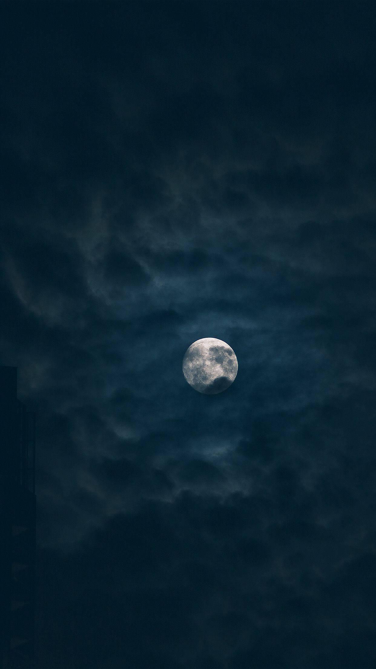 黑夜 桌布 壁紙 — 一輪明亮的滿月穿過旋轉的烏雲，在充滿氛圍的夜空中閃耀。