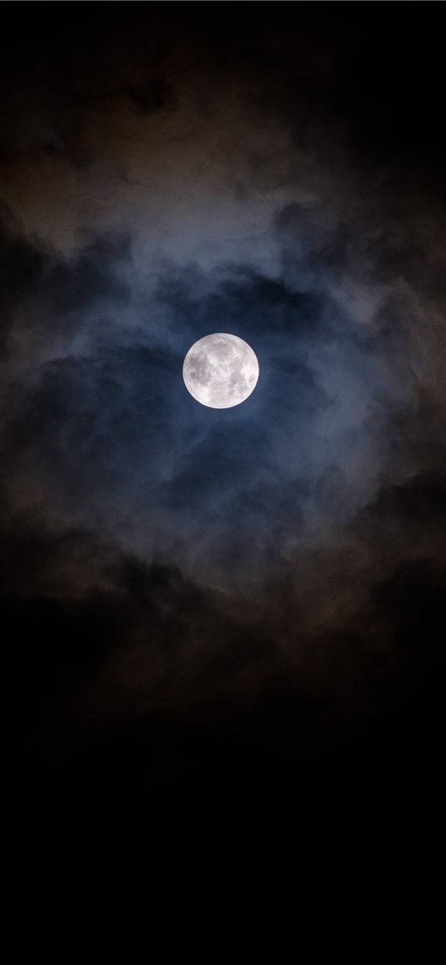 月光 桌布 壁紙 — 一輪明亮的滿月穿過深黑夜空中旋轉的烏雲閃耀。