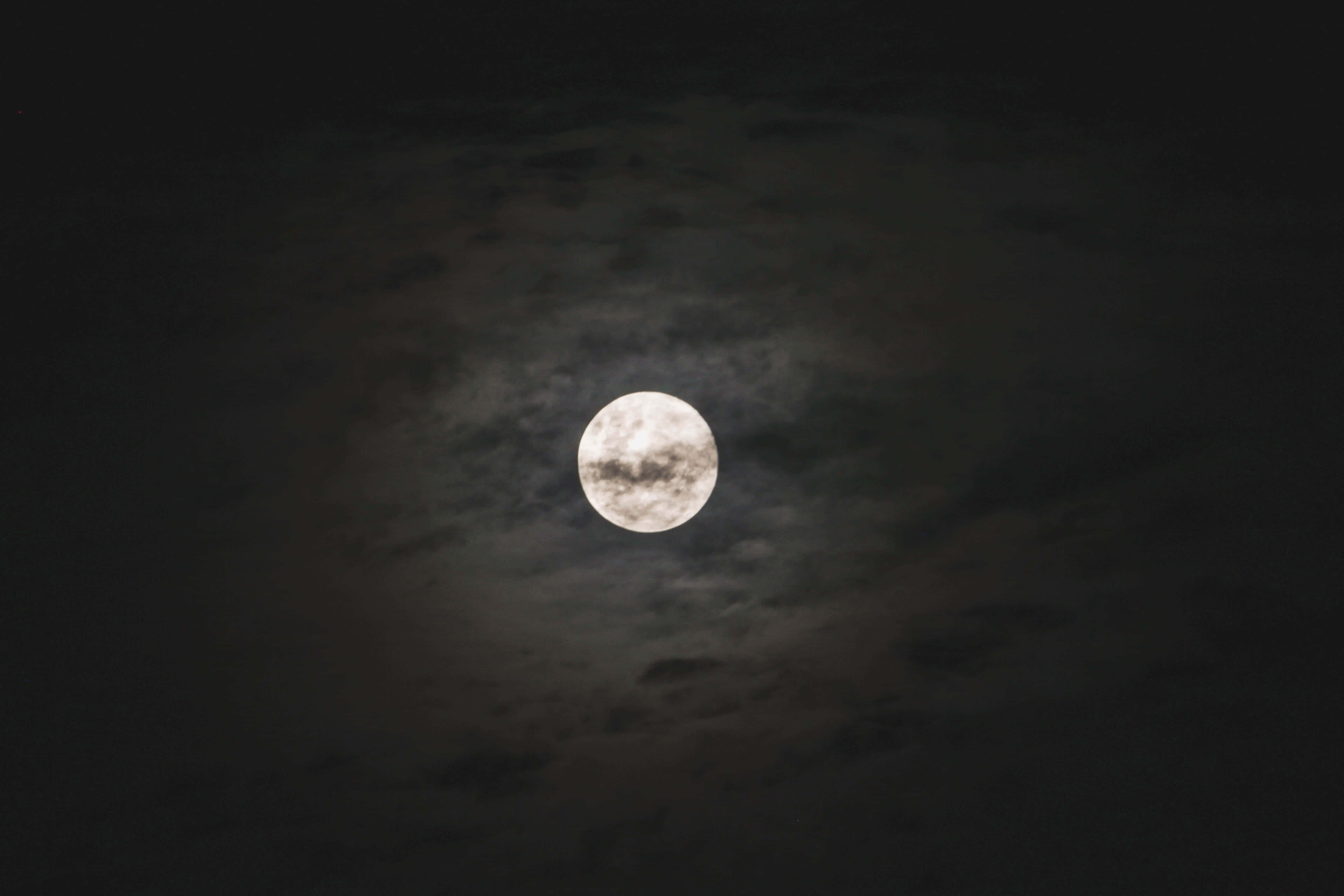 Dark Moon 桌布 壁紙 — 一輪明亮的滿月透過縷縷暗雲在深邃的夜空中閃耀。
