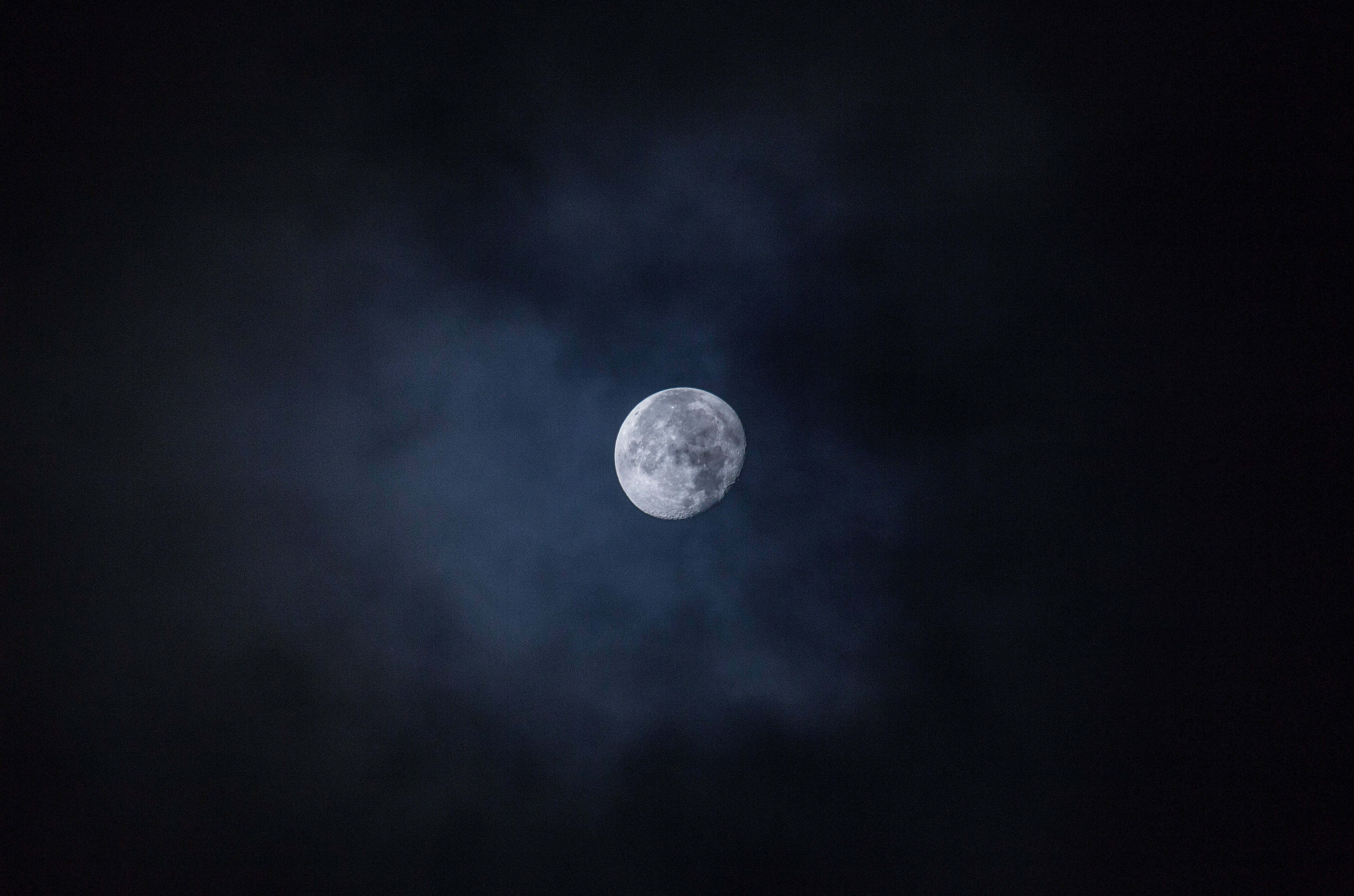 月光 桌布 壁紙 — 一輪明亮的滿月透過縷縷烏雲在深邃的夜空中發光。