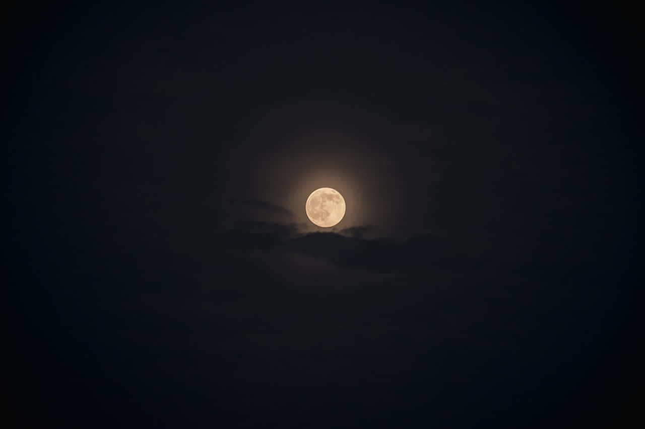 Night Time 桌布 壁紙 — 一輪明亮的滿月透過薄雲柔和地發光，映襯著深邃天鵝絨般的夜空。