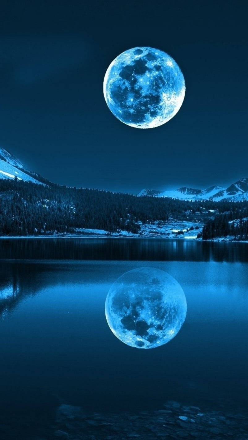 月光 桌布 壁紙 — 一輪明亮的藍月懸掛在積雪的山湖之上，在漆黑的夜空下完美倒映在平靜的水面上。
