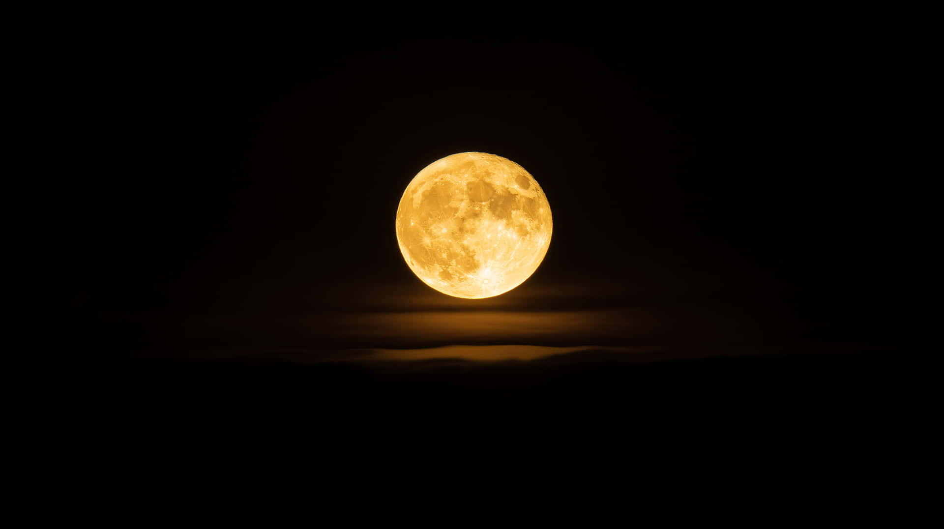 Golden Full Moon Rising Above Silhouetted Mountains in the Night Sky 壁紙 — 一輪明亮的金色滿月在漆黑的天空中強烈發光，下方有淡淡的雲層。