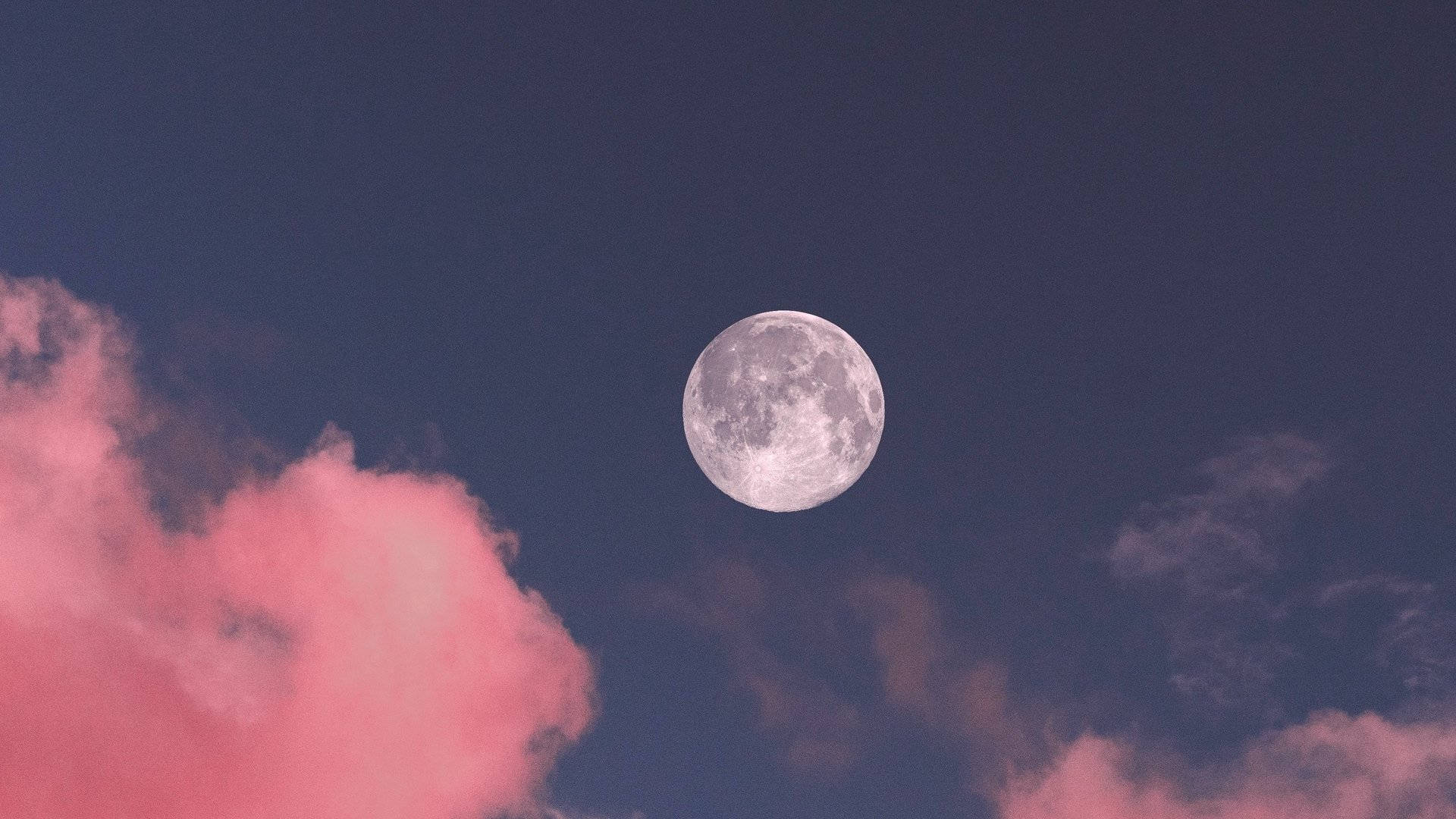 美學月亮 桌布 壁紙 — 一輪滿月在深藍色天空與柔和粉紅雲彩中寧靜地發光。