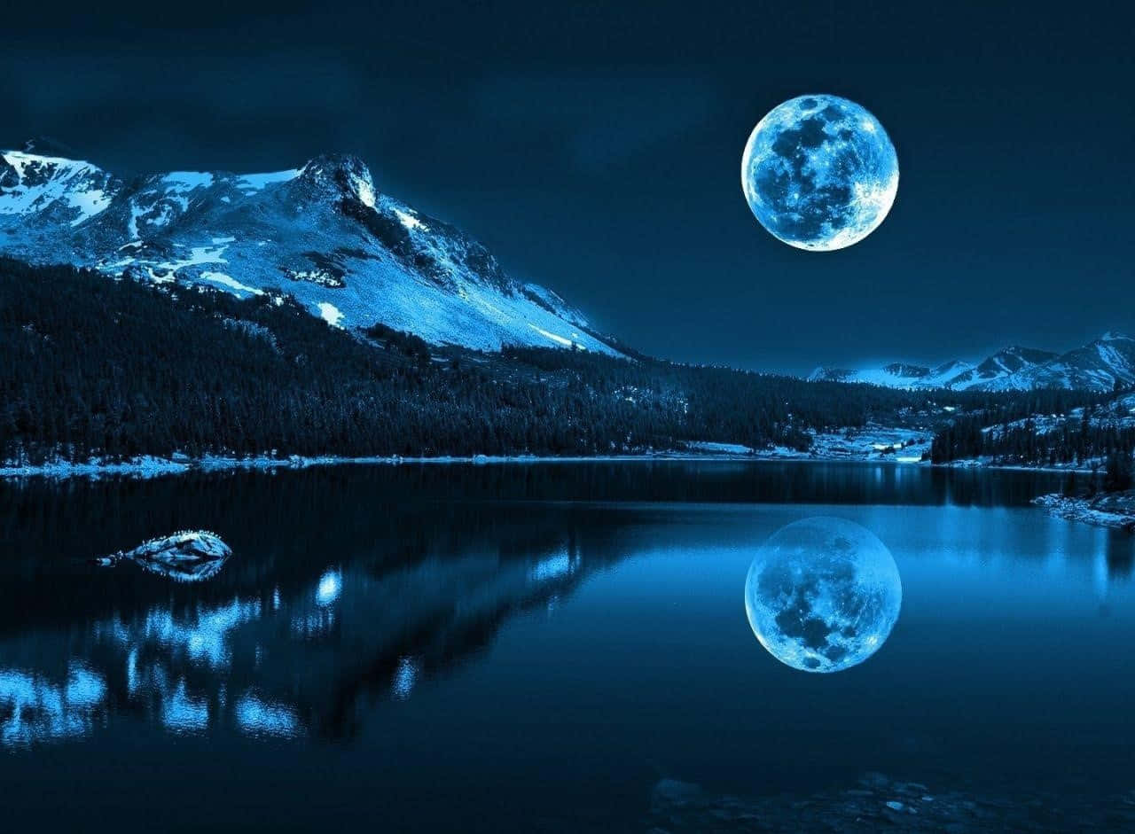 Beautiful Place 桌布 壁紙 — 一輪滿月在積雪的山峰上閃耀，倒映在黑暗夜空下寧靜的藍色湖泊中。
