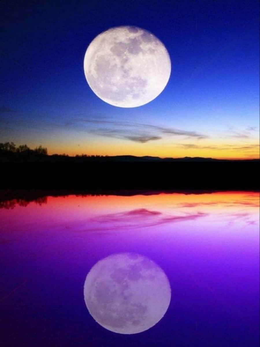 Beautiful Moon 桌布 壁紙 — 一輪滿月懸掛在暮色湖泊上空，水中倒映出鮮豔的紫色和橙色色調。