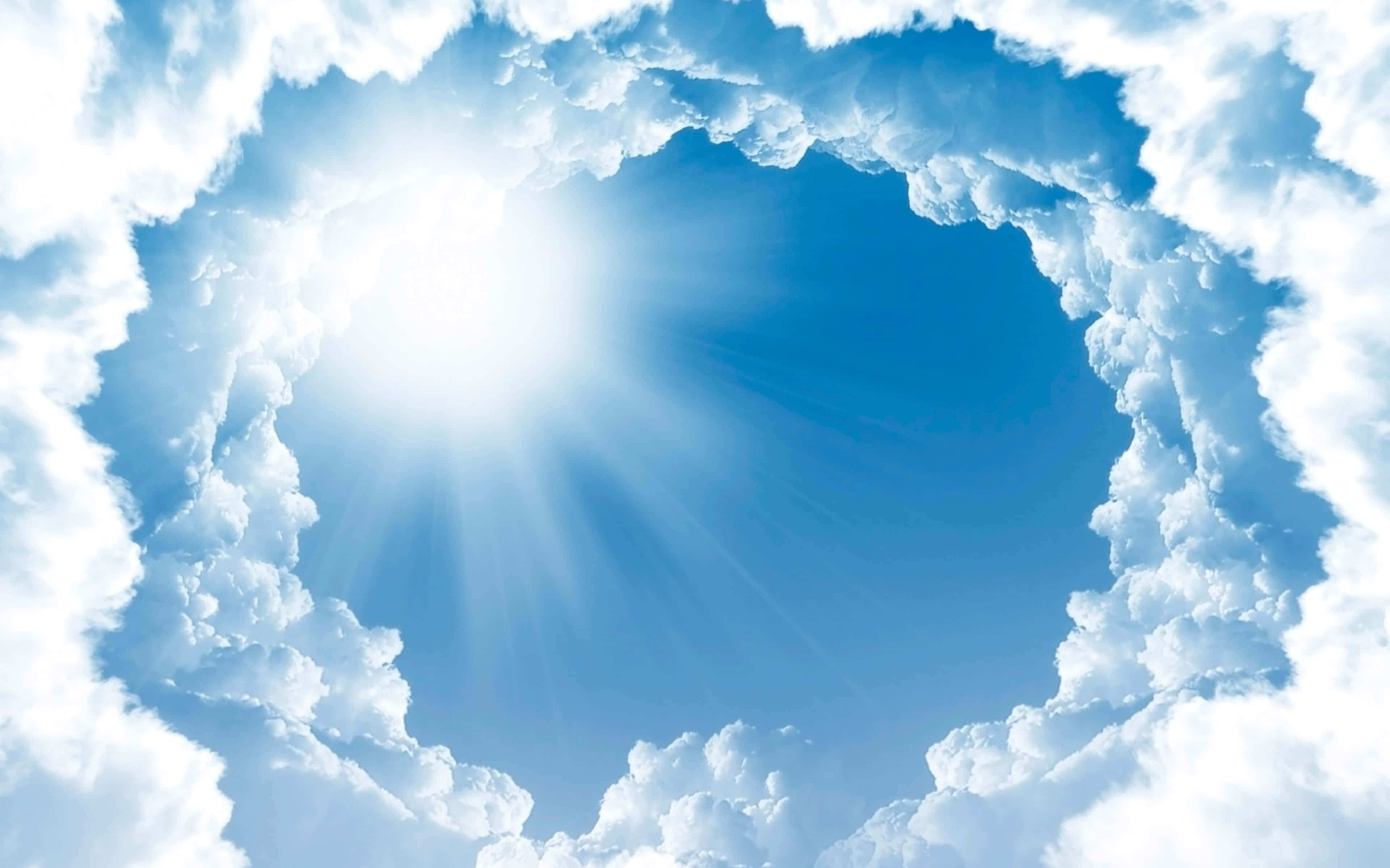 Heaven Rest In Peace 桌布 壁紙 — 一輪燦爛的太陽穿過由蓬鬆白雲組成的圓形框架，映襯著充滿活力的藍天。