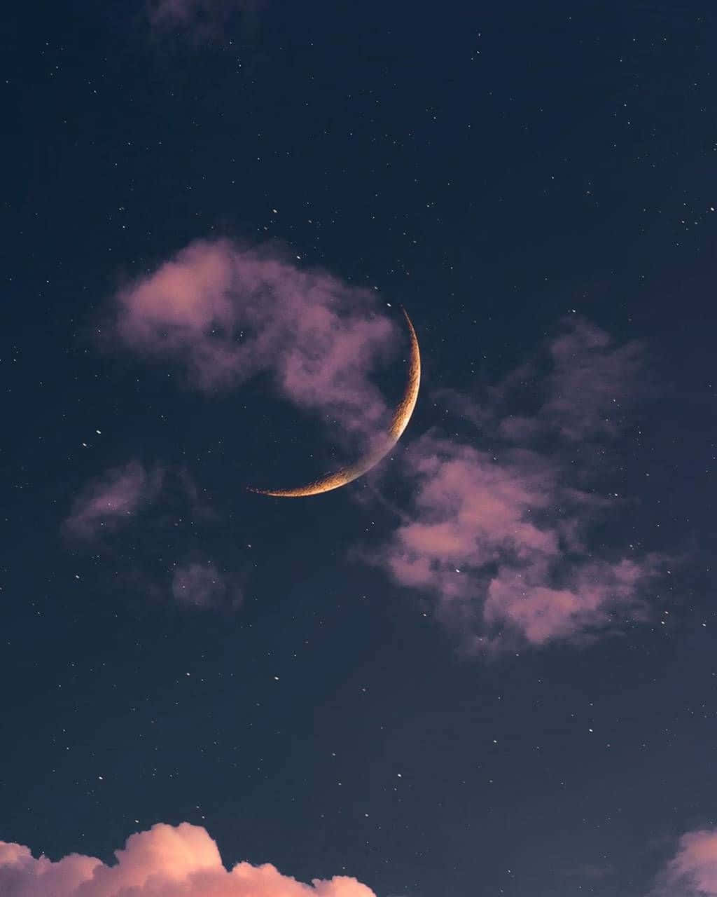 Moon And Stars iPhone 桌布 壁紙 — 一輪發光的彎月在繁星點點的午夜天空中，從柔軟的粉紅雲朵間探出頭來。