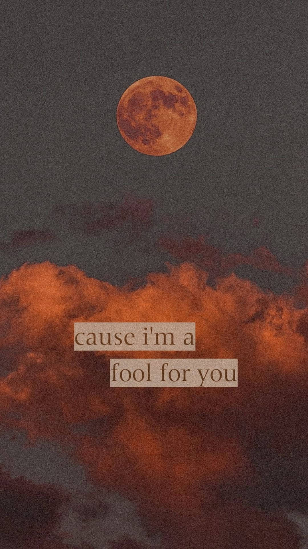 Aesthetic Love 桌布 壁紙 — 一輪發光的橙色月亮懸掛在火紅色的雲層之上，並附有文字 cause i'm a fool for you。