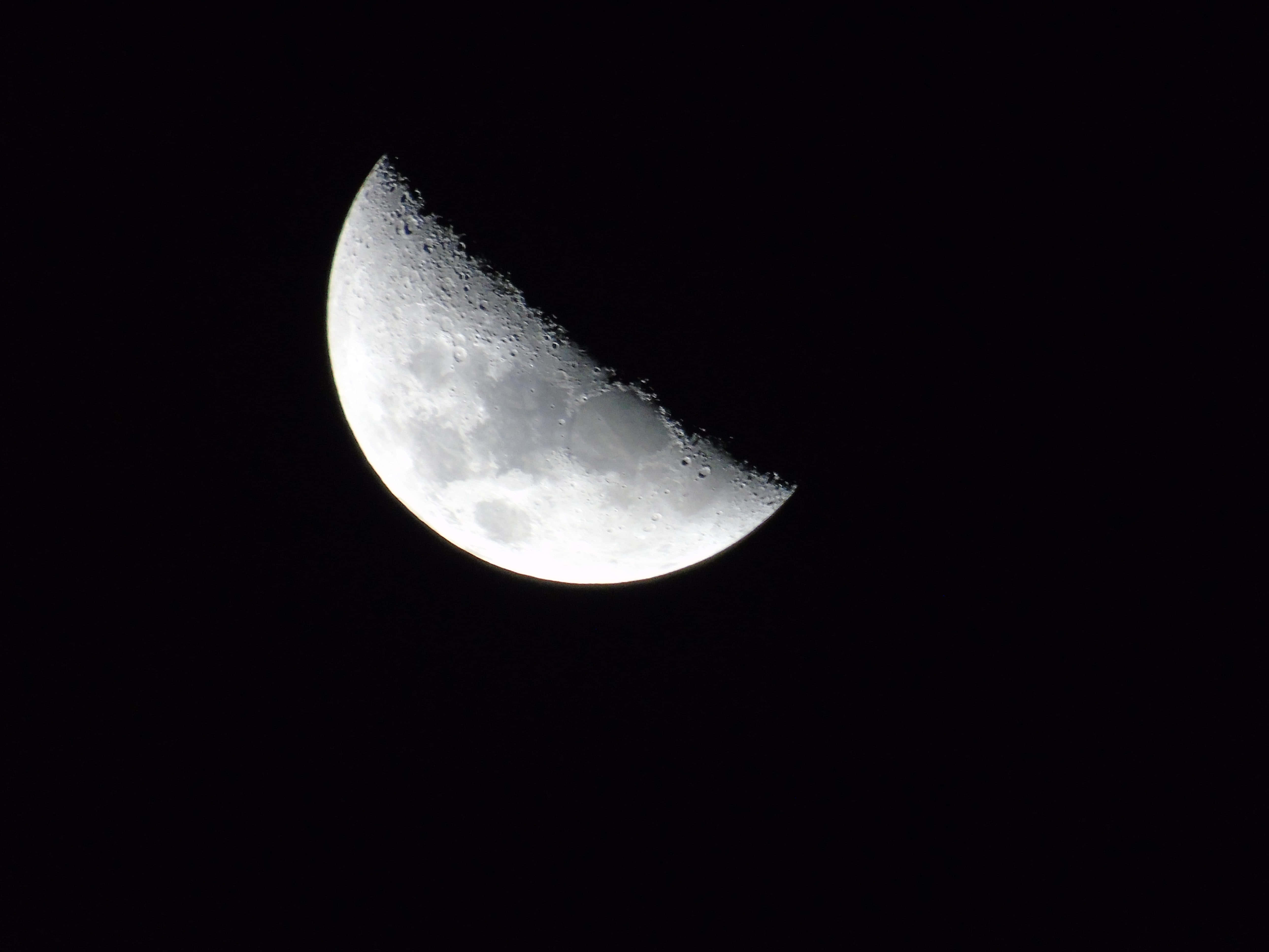 Half Moon 桌布 壁紙 — 一輪細節清晰的彎月在漆黑的夜空中閃耀，顯露出隕石坑和月球地形。