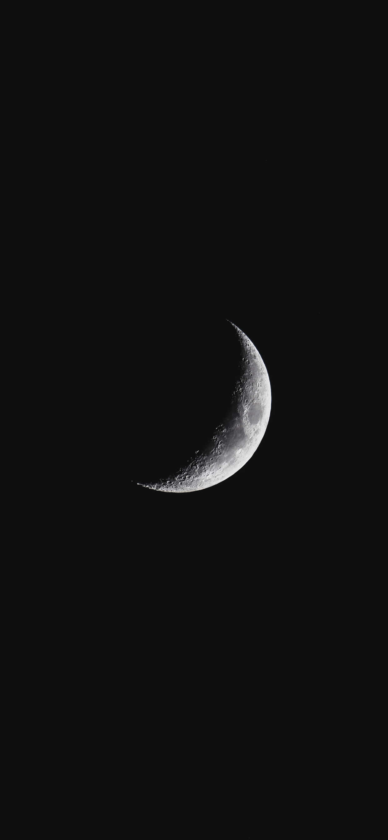 Moon iPhone 桌布 壁紙 — 一輪細節銳利的彎月在漆黑無星的夜空中閃耀。
