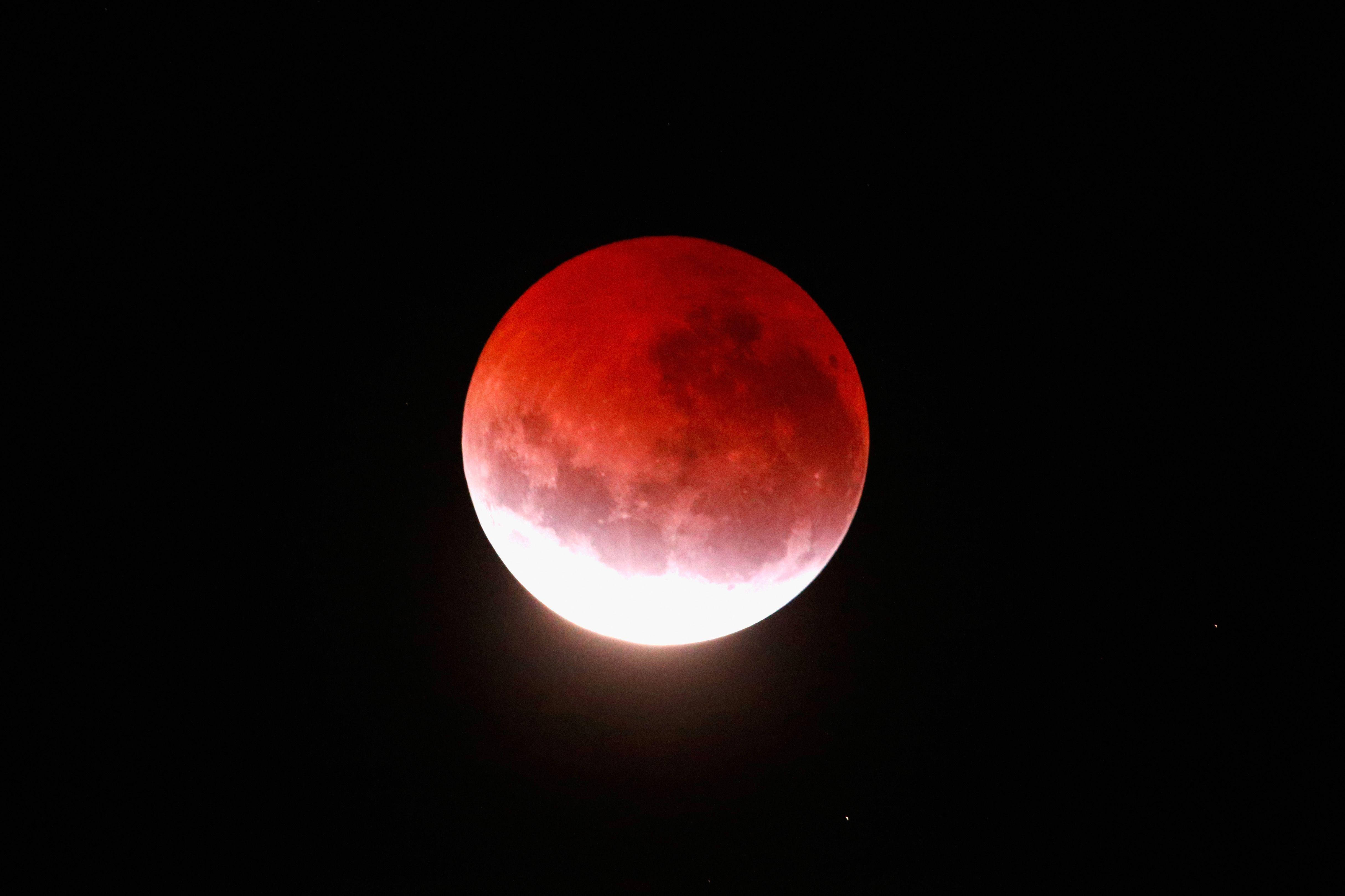 Eclipse 桌布 壁紙 — 一輪血紅色的月亮在漆黑的夜空中發光，隱約可見微弱的星星。