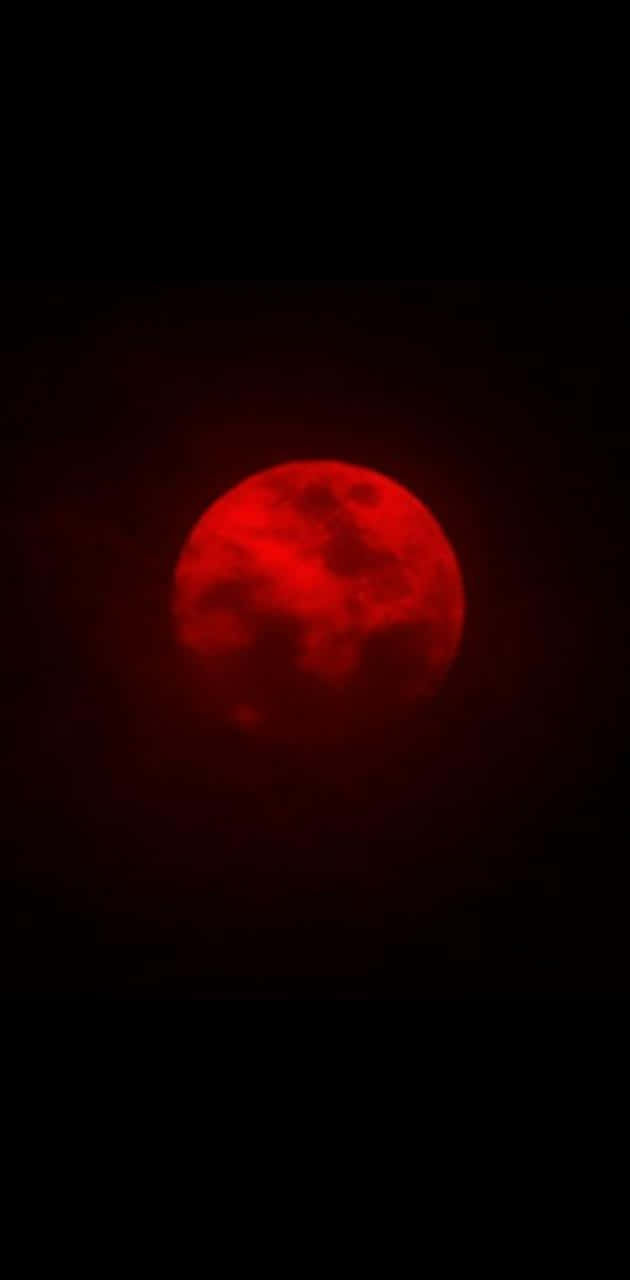 blood moon 桌布 壁紙 — 一輪鮮紅的月亮在漆黑一片、帶有微妙大氣薄霧的天空中強烈發光。