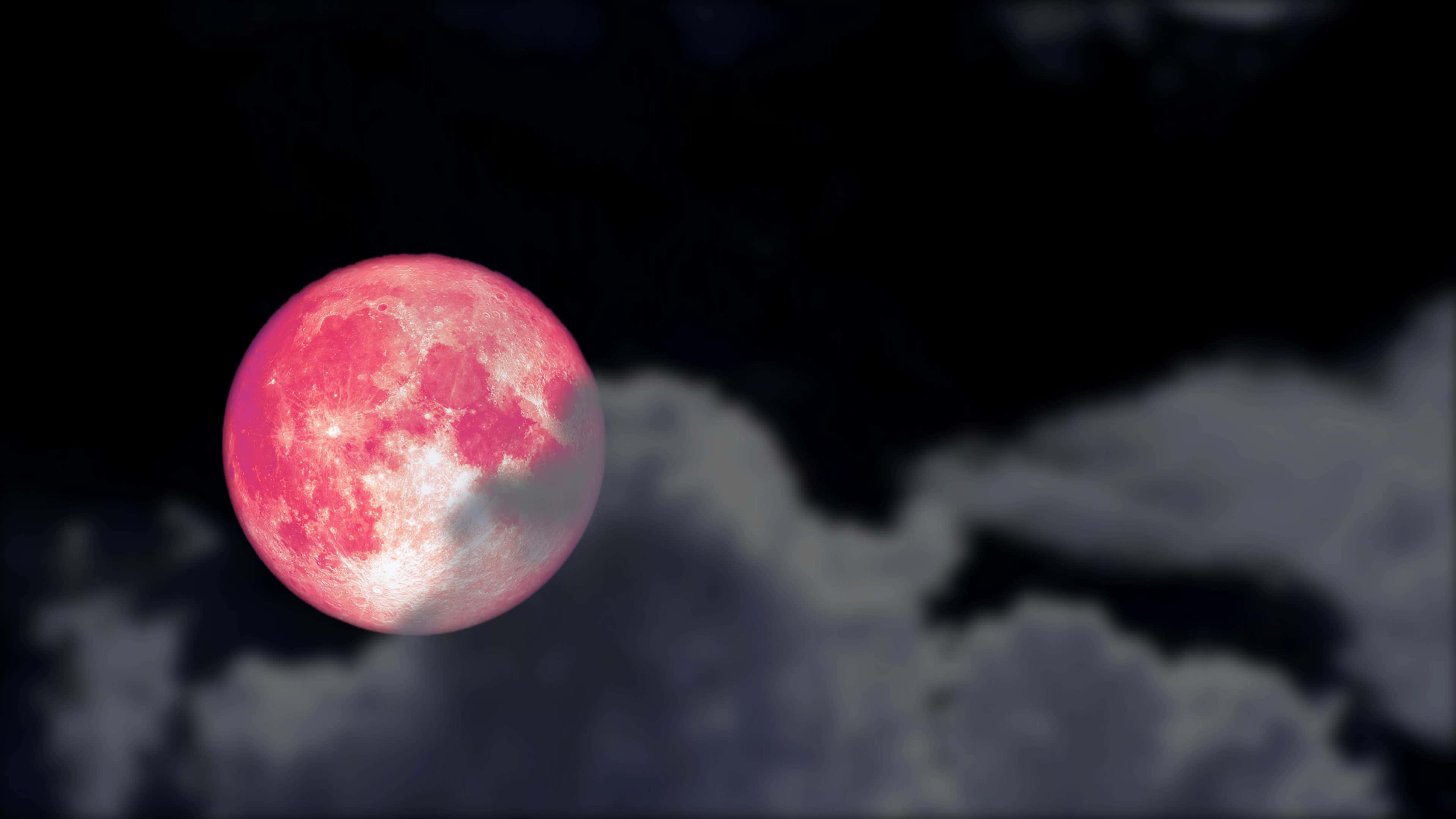 Pink Moon Real 桌布 壁紙 — 一輪鮮豔的粉紅月亮穿過烏雲在戲劇性的夜空中發光。