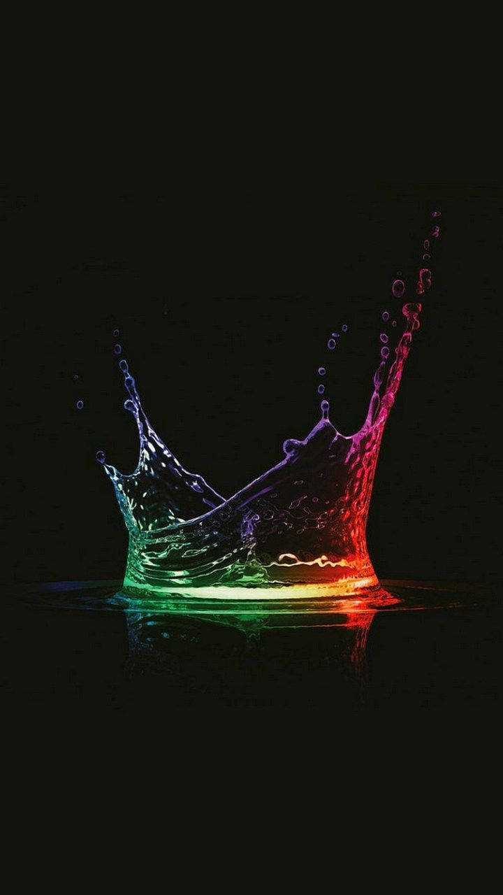 AMOLED 4K 桌布 壁紙 — 一道充滿活力的彩虹水花皇冠在純黑背景上噴發，帶有發光的反射。