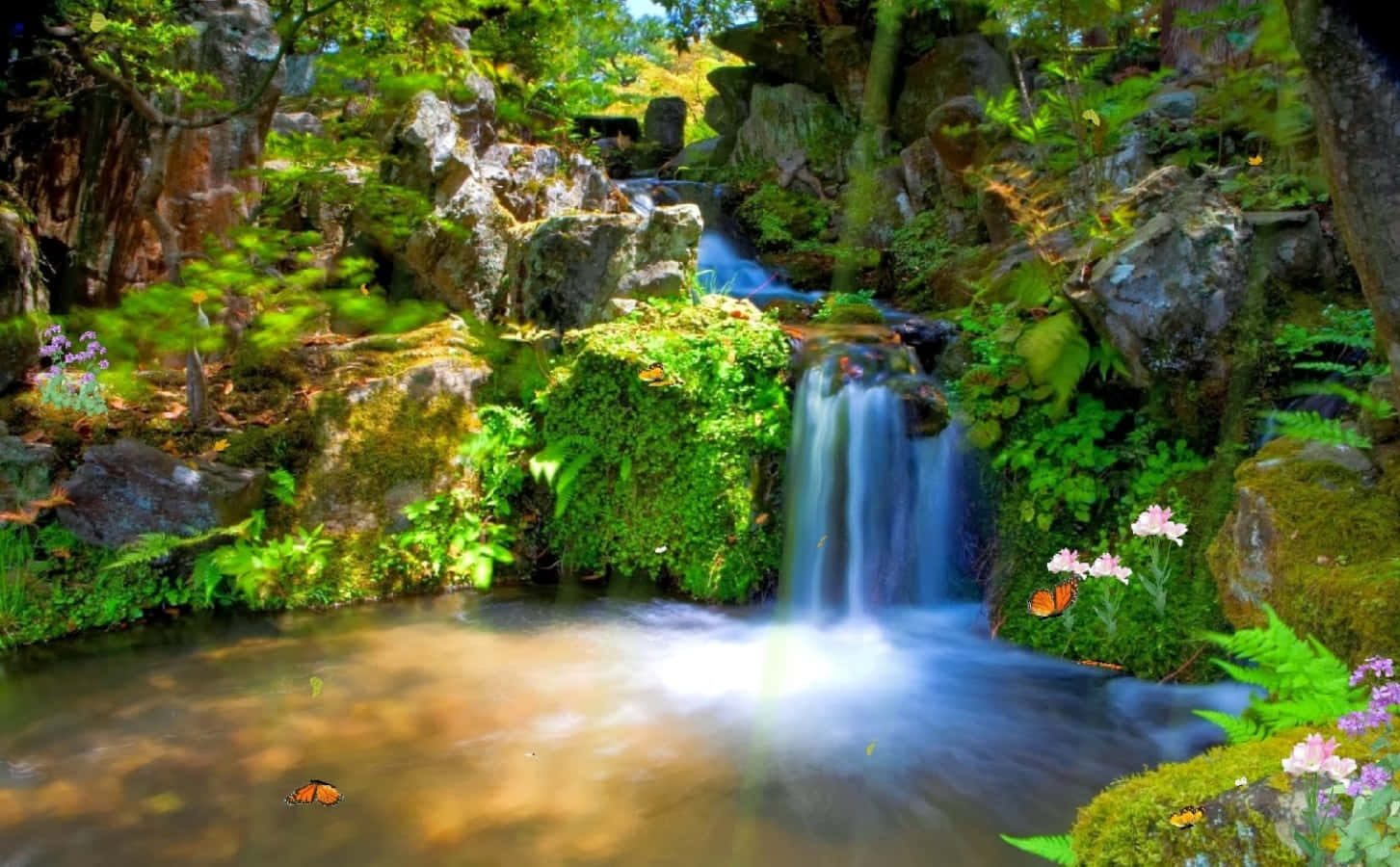 screensaver 桌布 壁紙 — 一道充滿活力的瀑布從長滿苔蘚的岩石上傾瀉而下，流入一個陽光明媚的水池，周圍環繞著茂密的綠植和色彩繽紛的花朵。