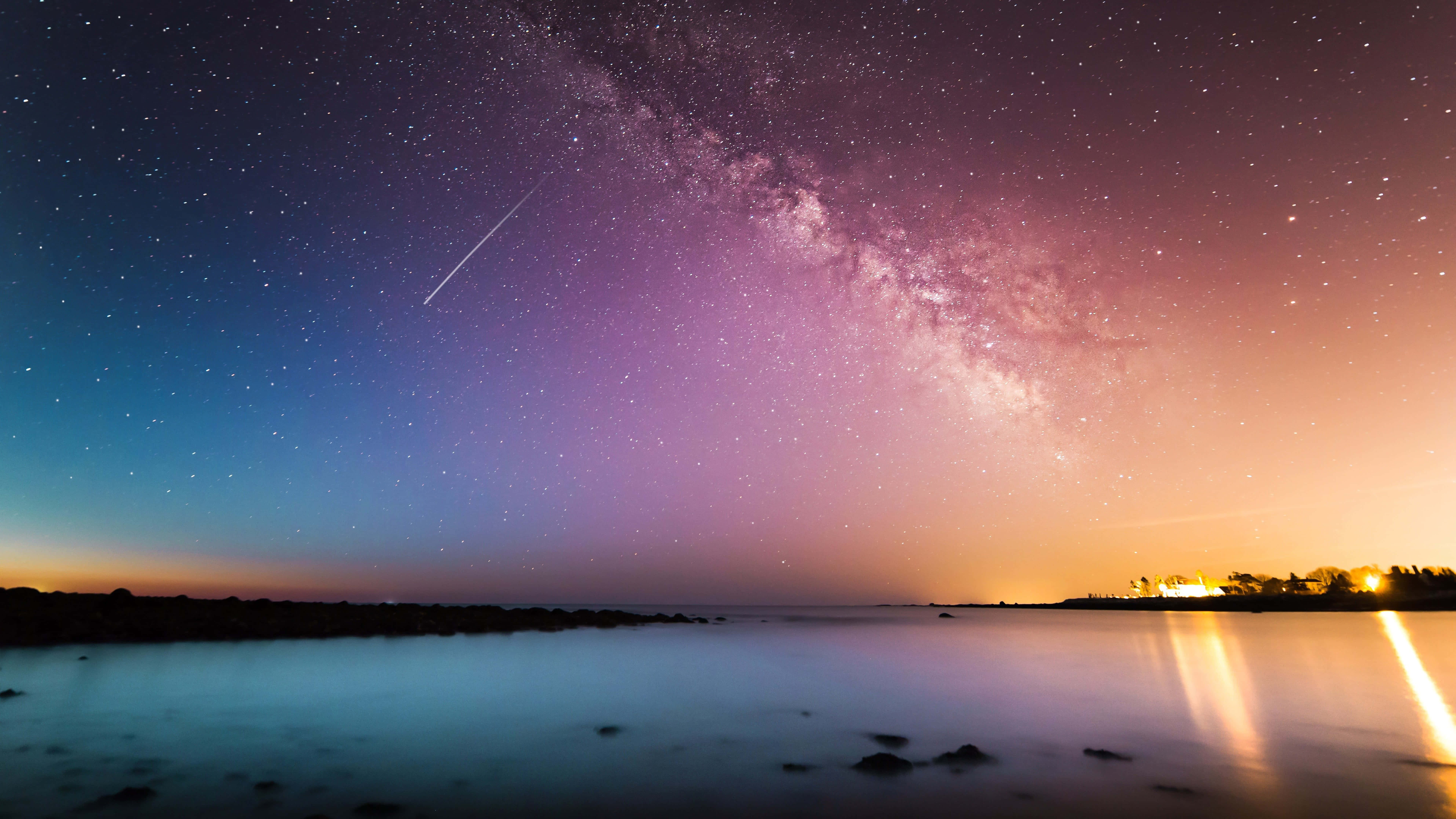 Starry Sky 桌布 壁紙 — 一道天體劃過銀河，在寧靜的暮色湖面上反射出遠方的燈光。