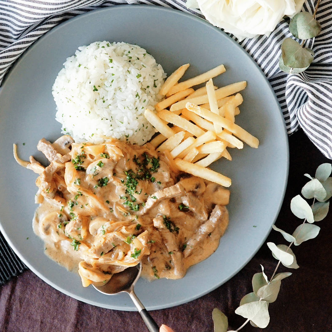 Food Photography 桌布 壁紙 — 一道奶油蘑菇雞肉料理，搭配薯條和米飯，置於灰色盤中，以歐芹點綴，並以尤加利葉和白玫瑰環繞。