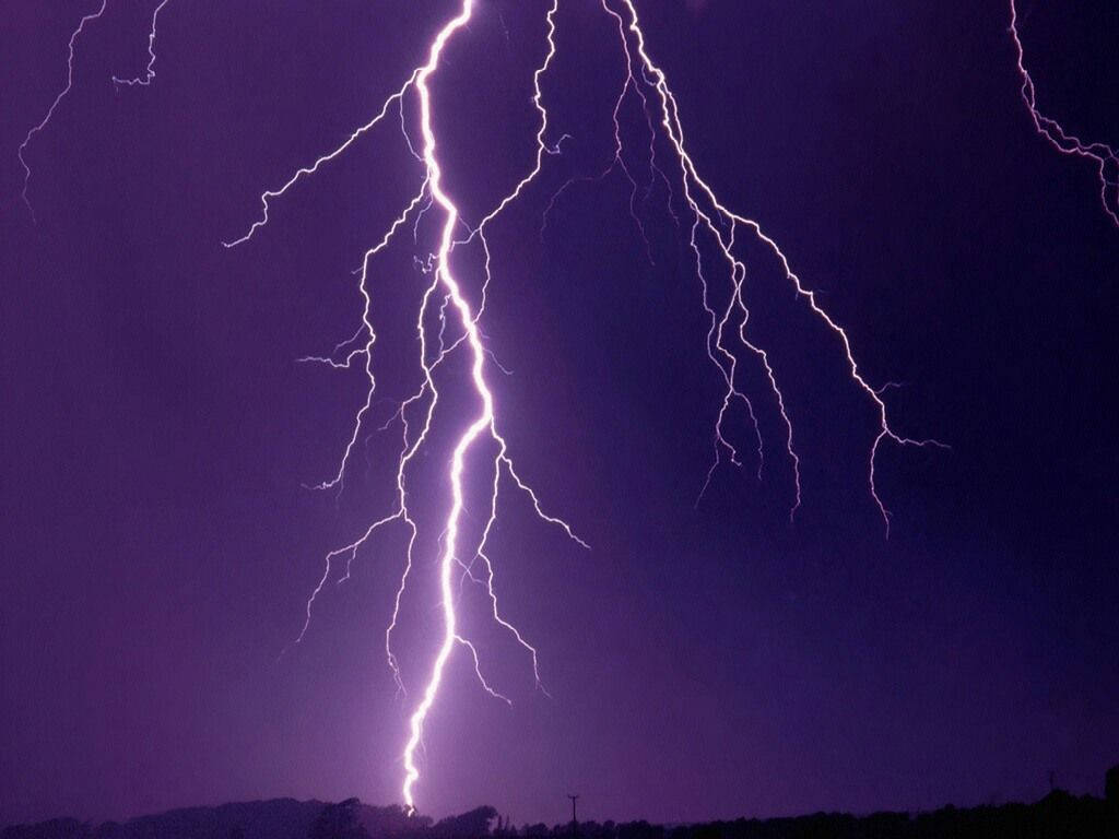 Aesthetic Lightning 桌布 壁紙 — 一道巨大的紫色閃電在黑暗風暴天空上分叉，越過剪影地平線。