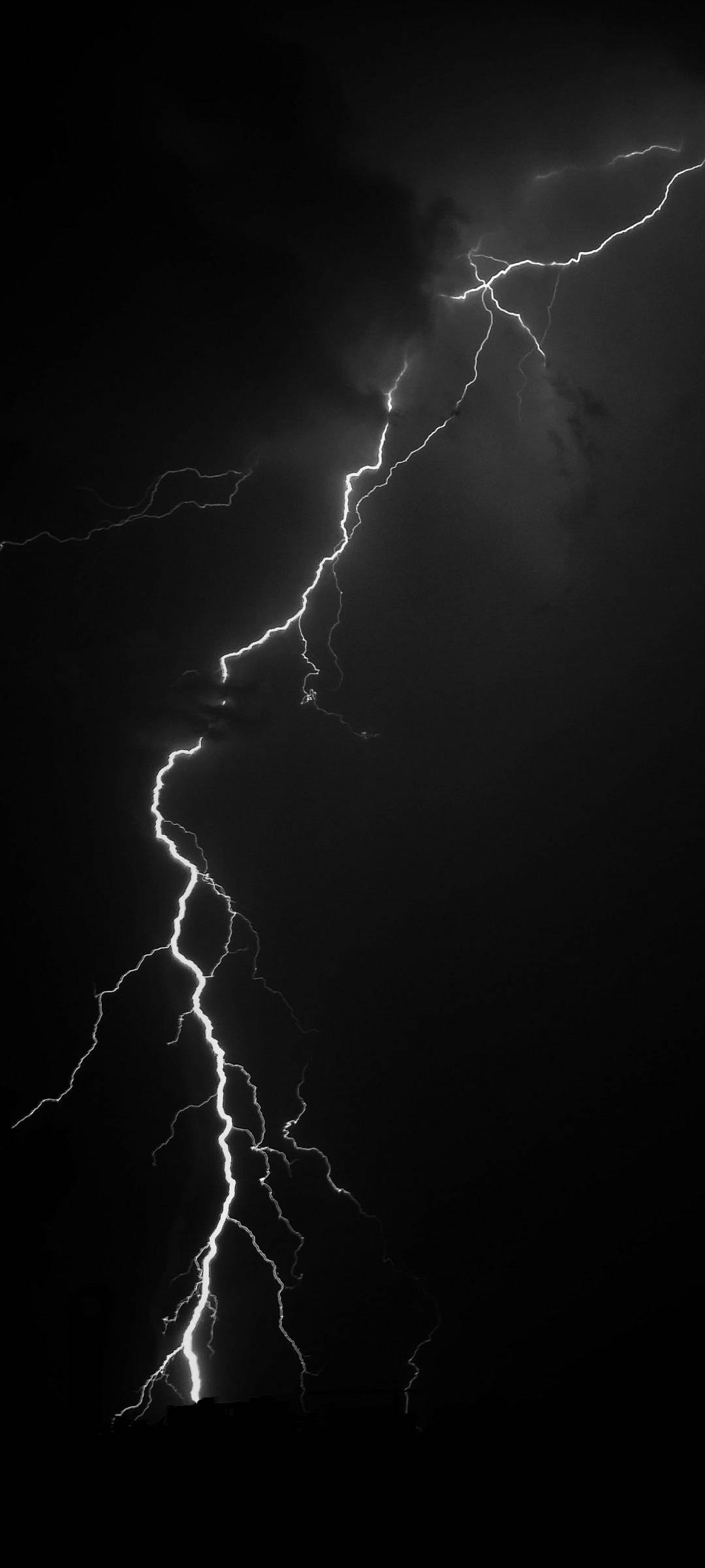 閃電 桌布 壁紙 — 一道巨大的閃電在漆黑的暴風雨天空中戲劇性地垂直劈開，形成分叉。