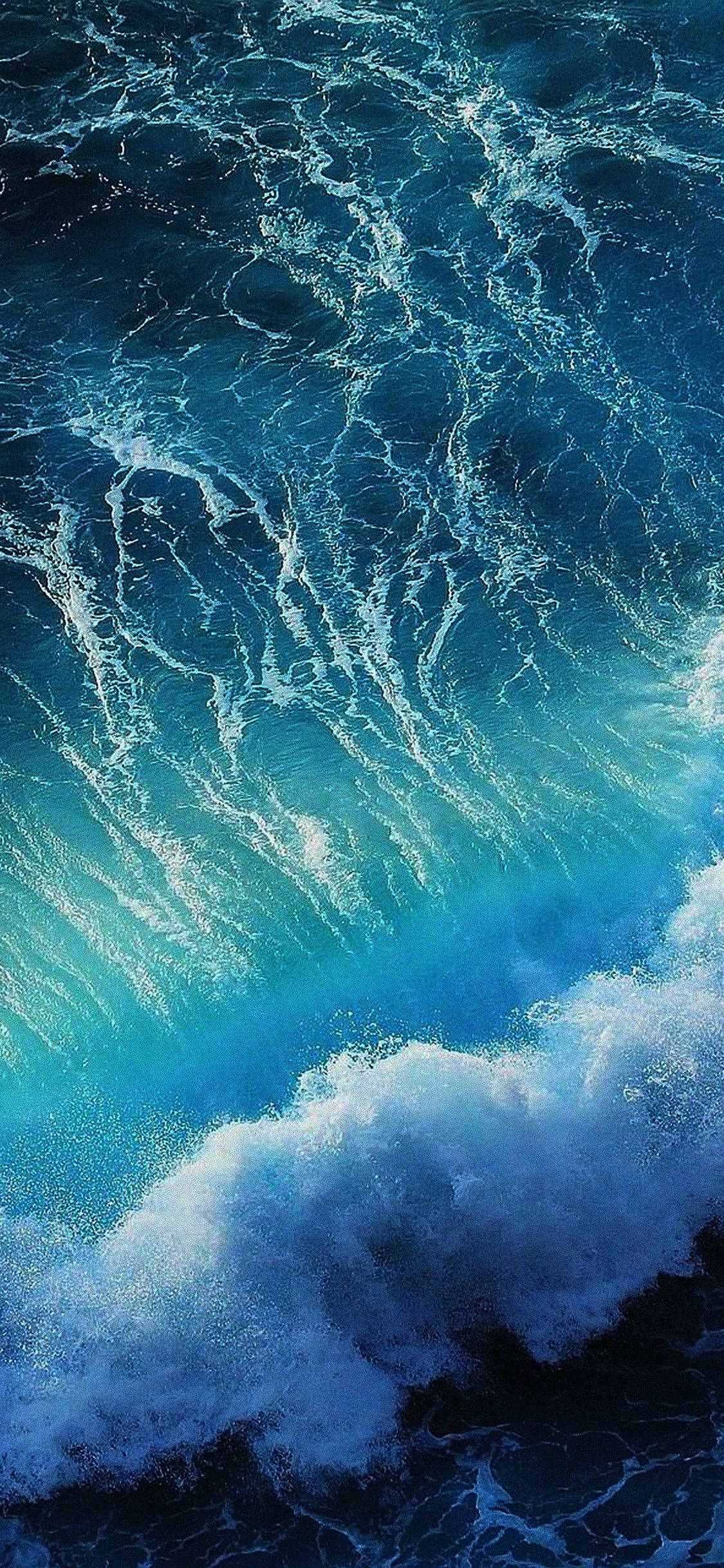 Aesthetic Ocean 桌布 壁紙 — 一道強勁的海浪向上衝擊，呈現鮮豔的藍綠色和深藍色，帶有泡沫狀的白色浪花。