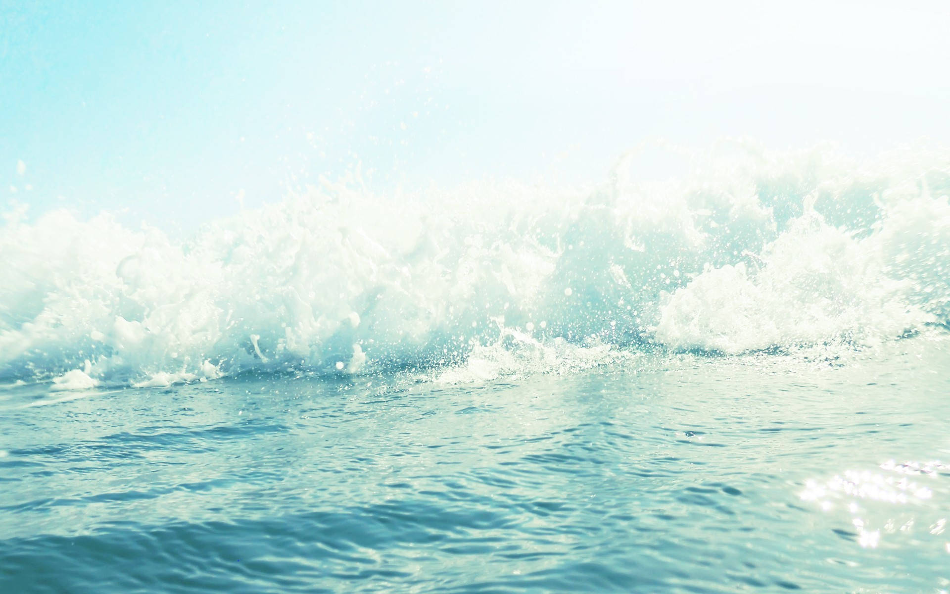 水 桌布 壁紙 — 一道強勁的海浪在明亮的日光下撞擊平靜的碧綠海水，激起白色泡沫飛濺。