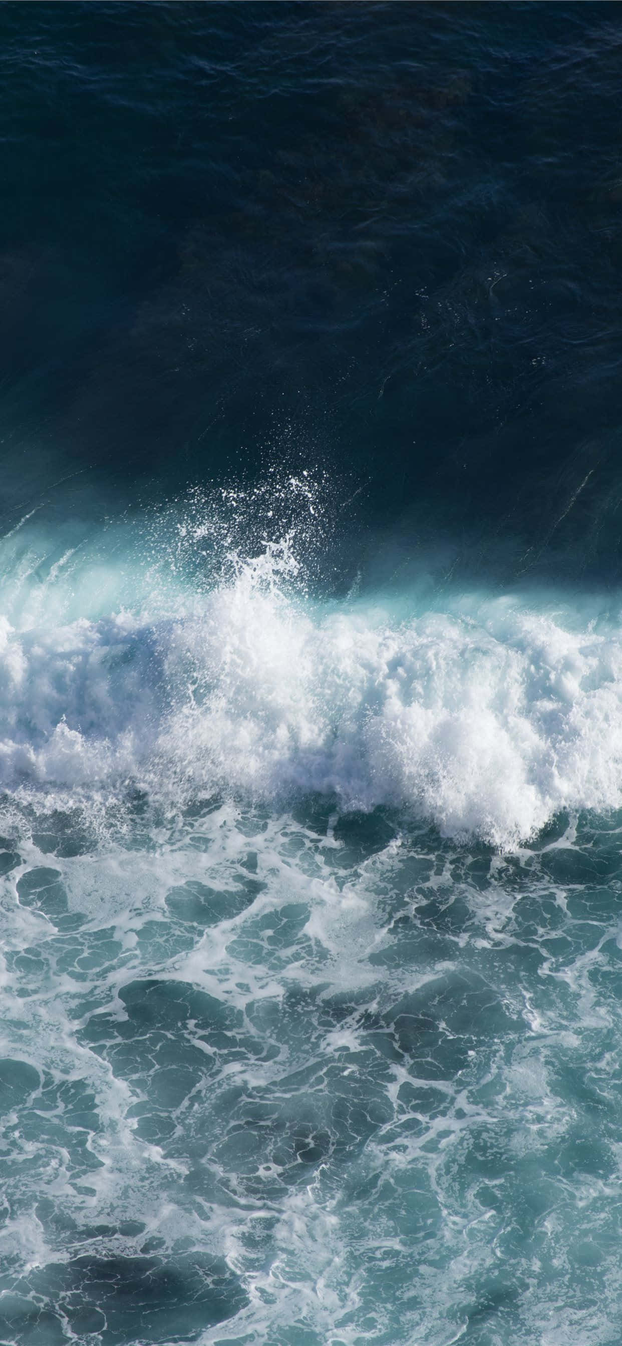 waves 桌布 壁紙 — 一道強勁的海浪拍打著白色泡沫，撞擊深藍色的海水，形成一個戲劇性的垂直畫面。