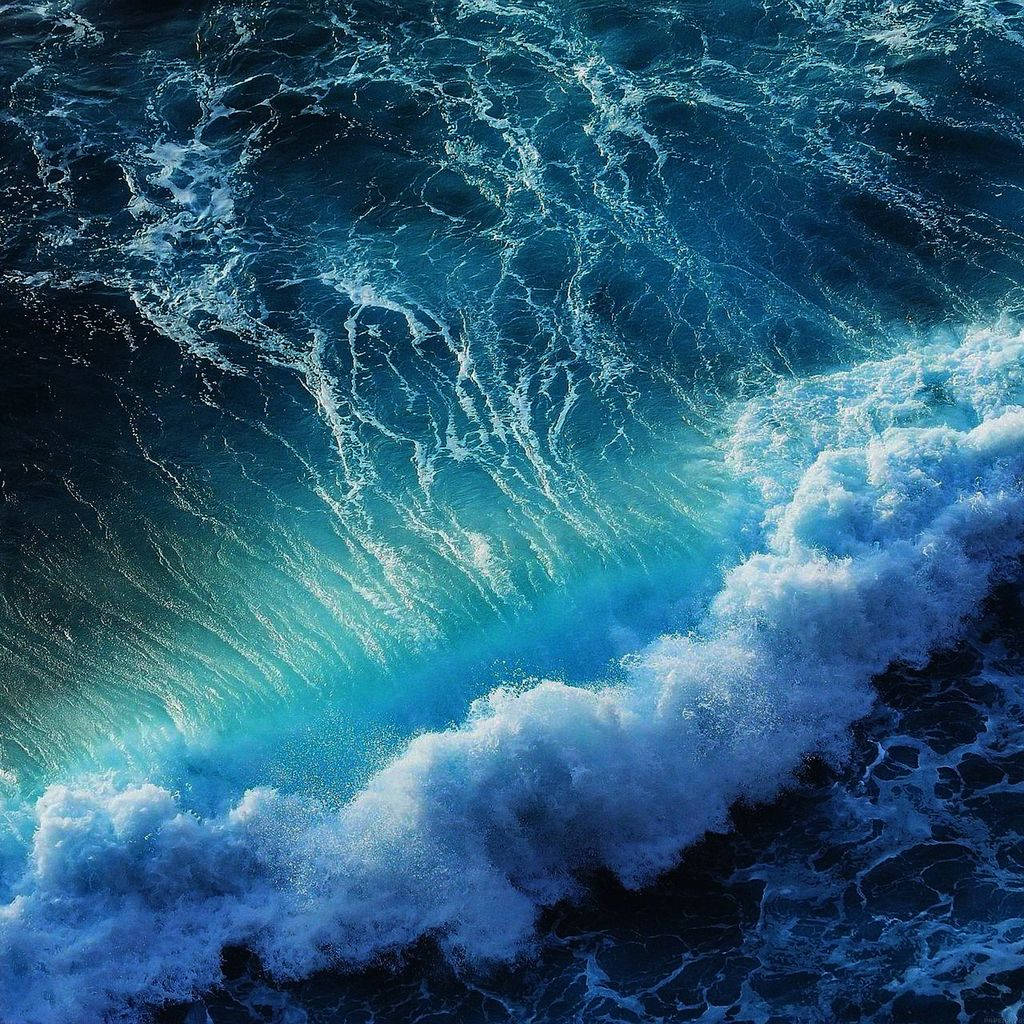 一道戲劇性的海浪，帶有藍綠色和深藍色的海水。 — iPad mini 動態圖片 壁紙