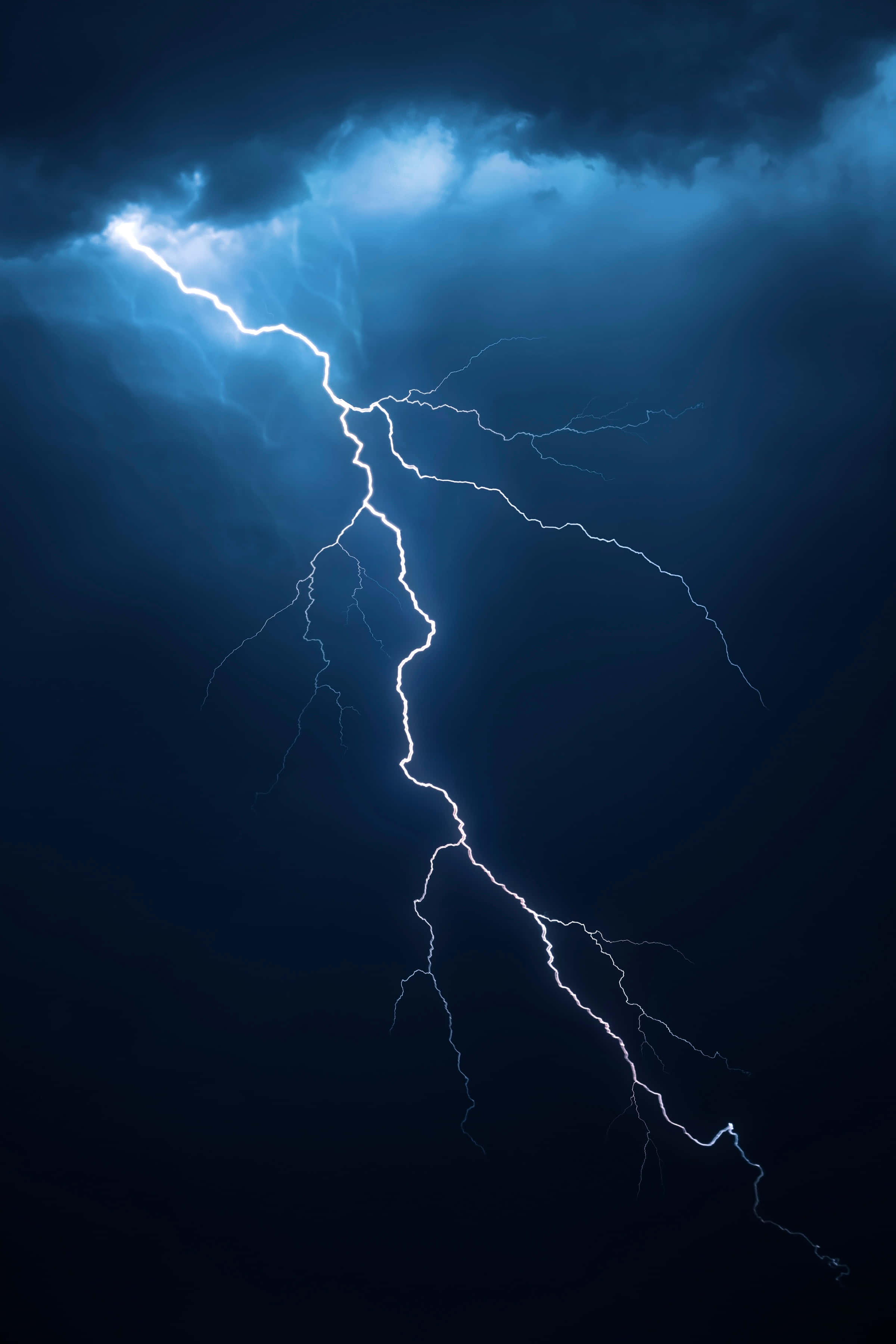 暴風 桌布 壁紙 — 一道強勁的藍白色閃電在黑暗的暴風雨中戲劇性地分叉。