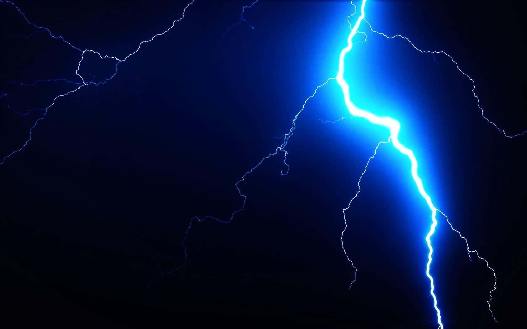 閃電 桌布 壁紙 — 一道強勁的藍色閃電在漆黑的天空中分叉，展現出戲劇性的自然景象。