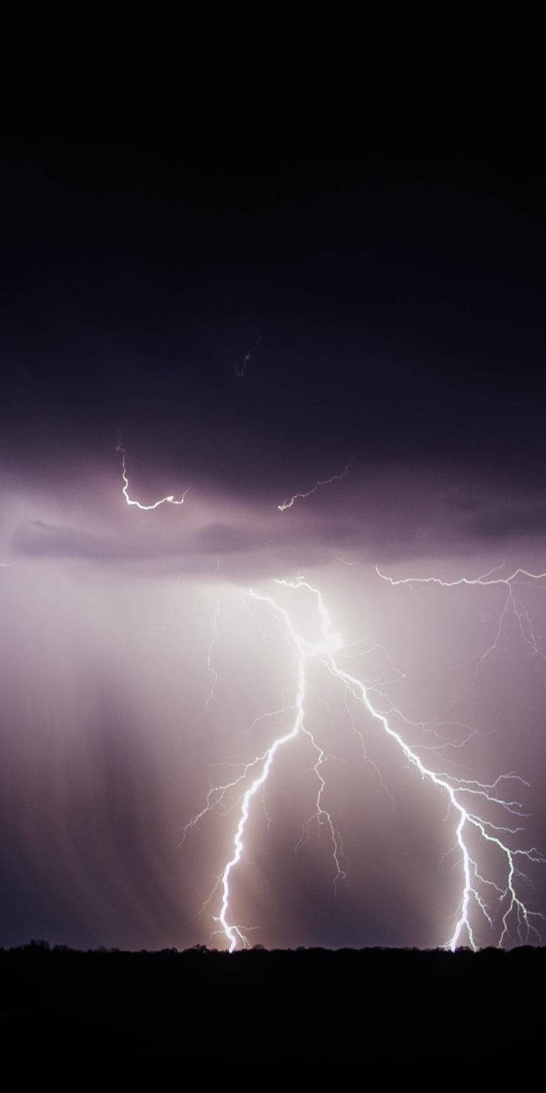iPhone 桌布 壁紙 — 一道強勁的閃電照亮了黑暗暴風雨的天空，下方是剪影般的地平線。