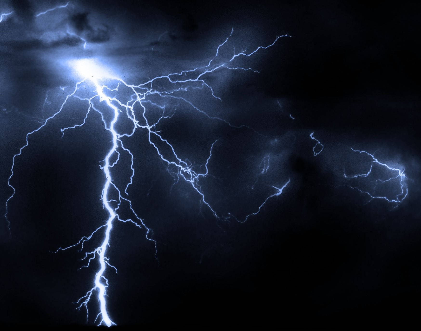 閃電 桌布 壁紙 — 一道強勁的電藍色閃電在黑暗的暴風雨中岔開，形成戲劇性的自然景象。