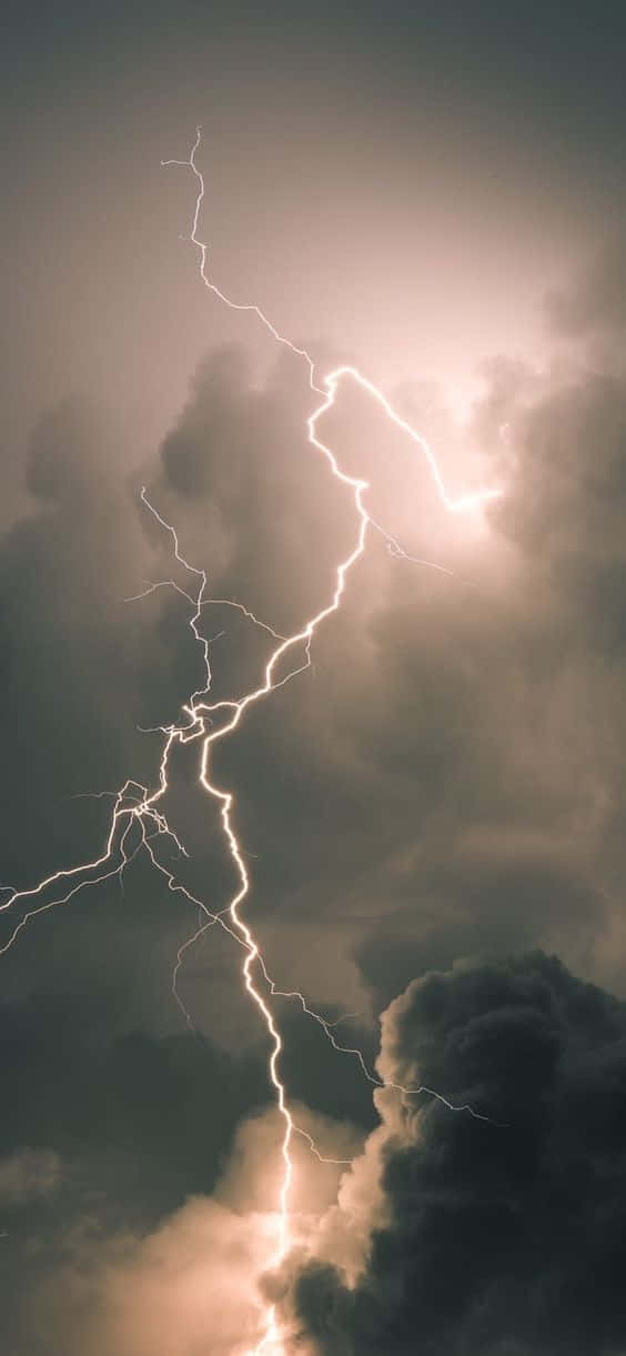 Cool Lightning 桌布 壁紙 — 一道強大的閃電在暴風雨的天空中分叉，照亮濃密的雲層，形成戲劇性的對比。
