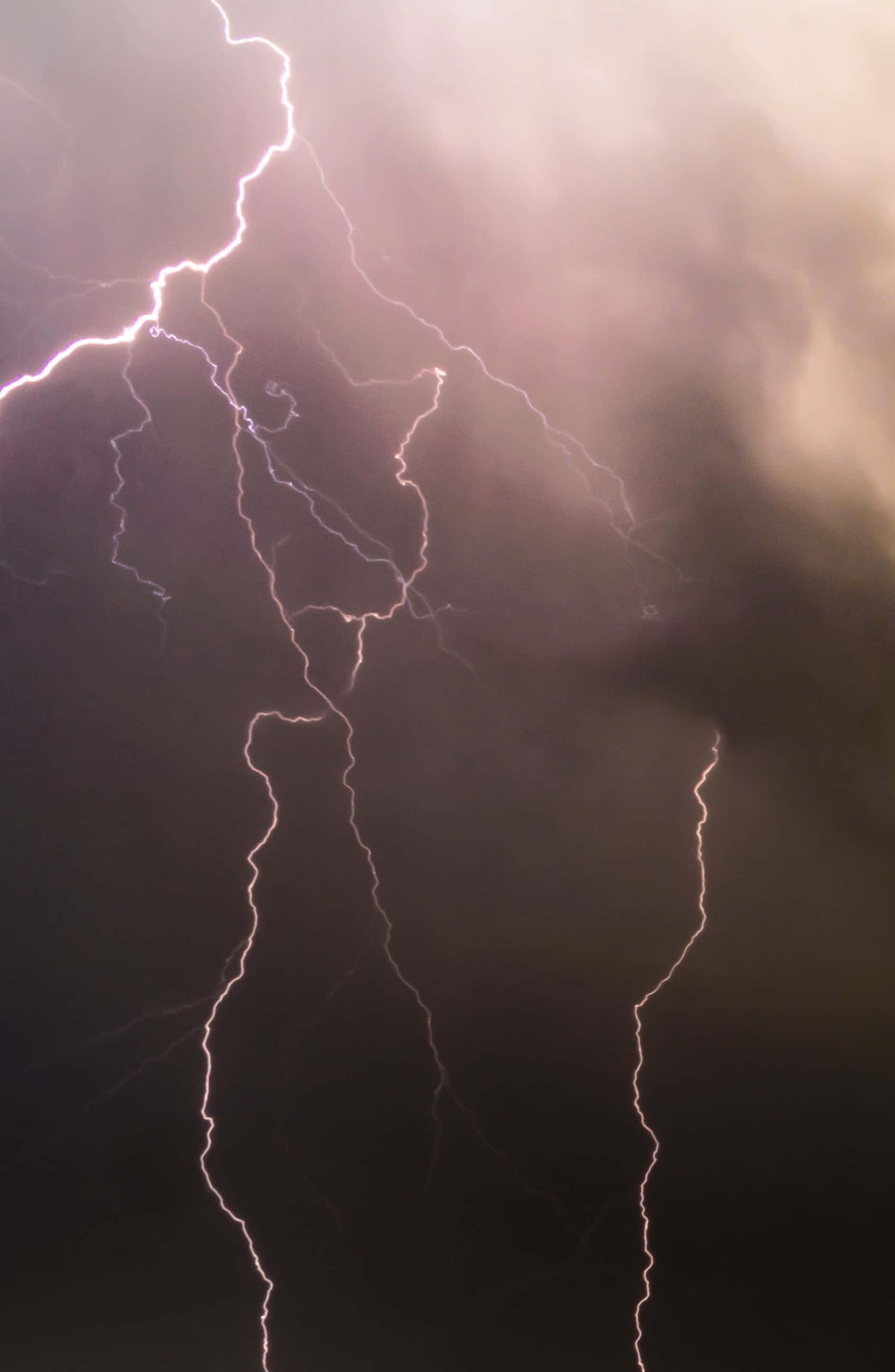 Lightning Bolt iPhone 桌布 壁紙 — 一道強大的閃電在黑暗的暴風雨中分叉，在旋轉的雲層上投射出電光。