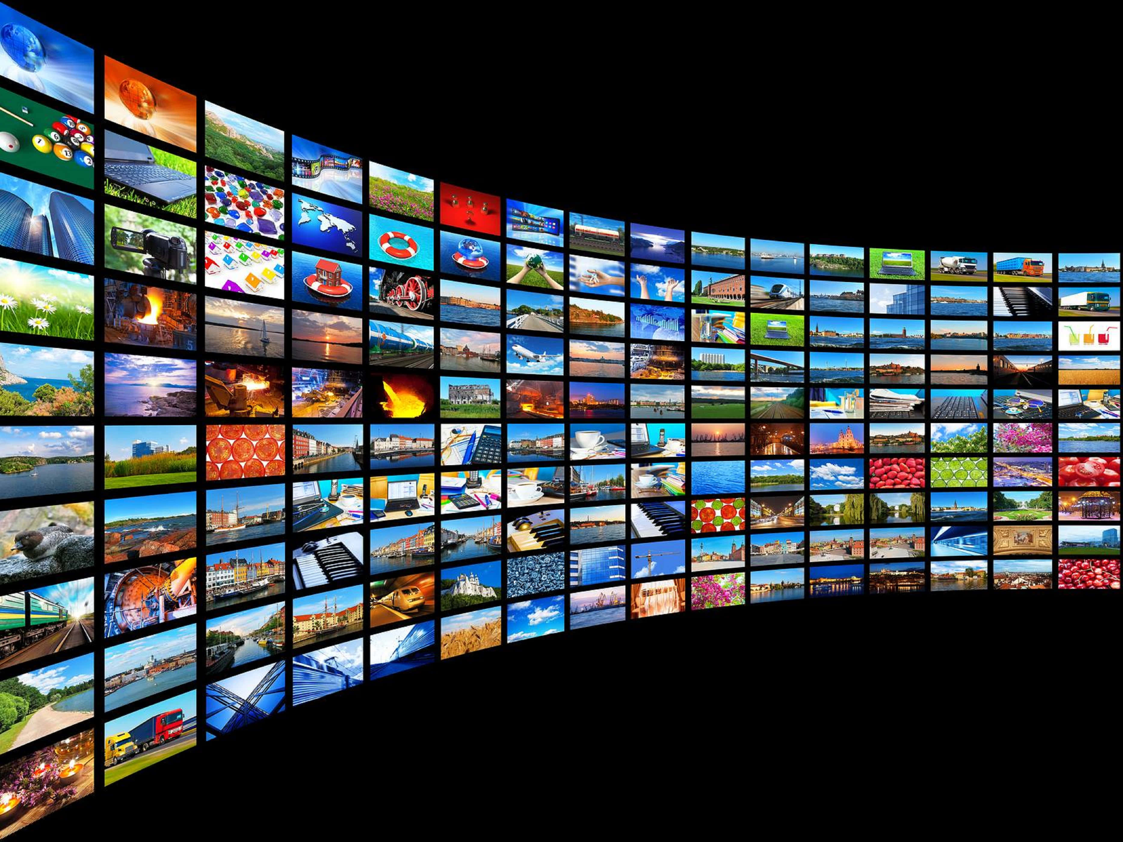 4K Streaming 桌布 壁紙 — 一道彎曲的發光螢幕牆，在黑色虛空背景下展示從自然到城市生活的多樣全球場景的鮮明拼貼畫。