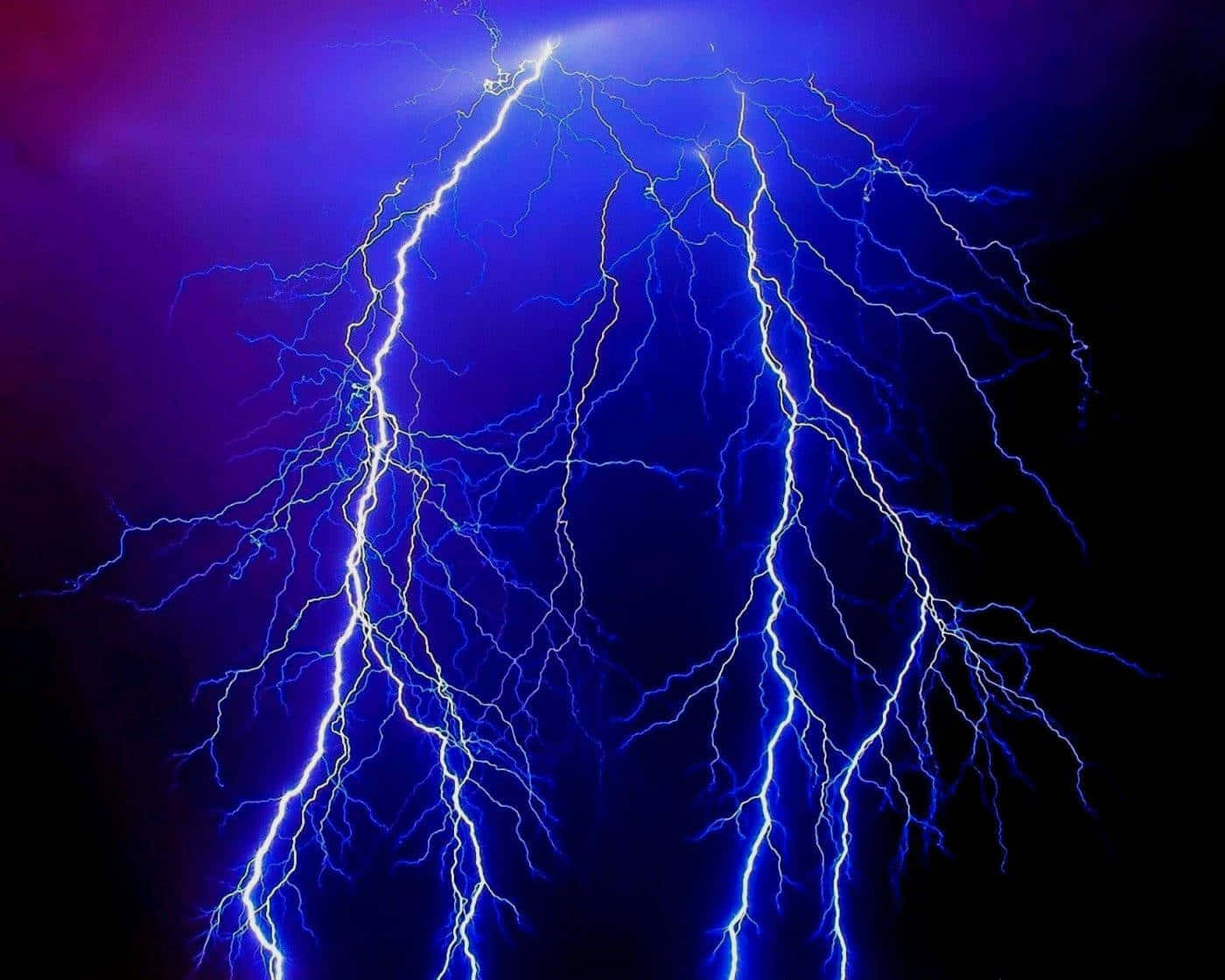 閃電 桌布 壁紙 — 一道戲劇性的電藍色閃電在深紫色和黑色的暴風雨天空中分叉。