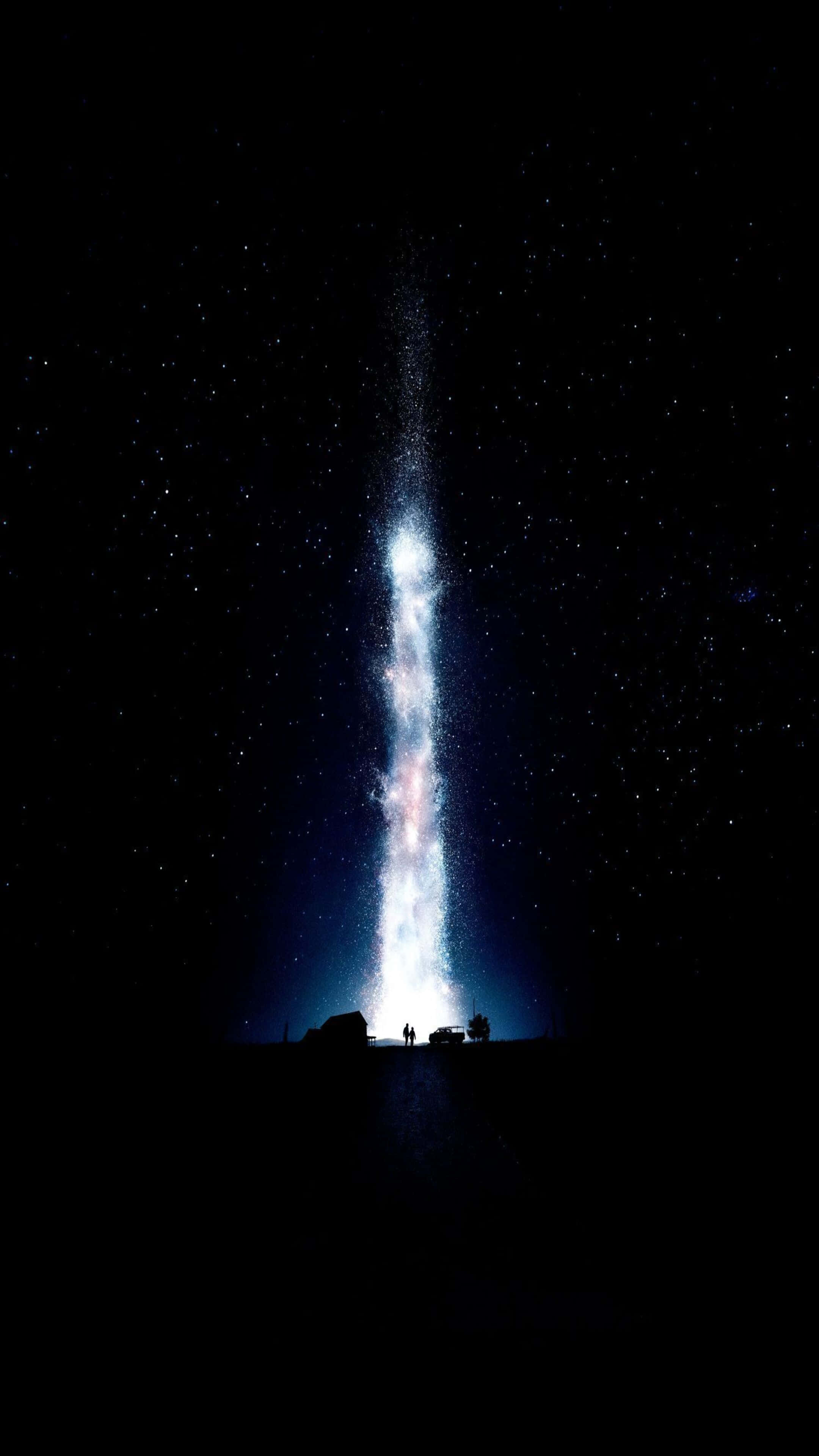 桌布 壁紙 — 一道由星星組成的宇宙瀑布從夜空傾瀉而下，落入黑暗的景觀中，小小的剪影敬畏地仰望。