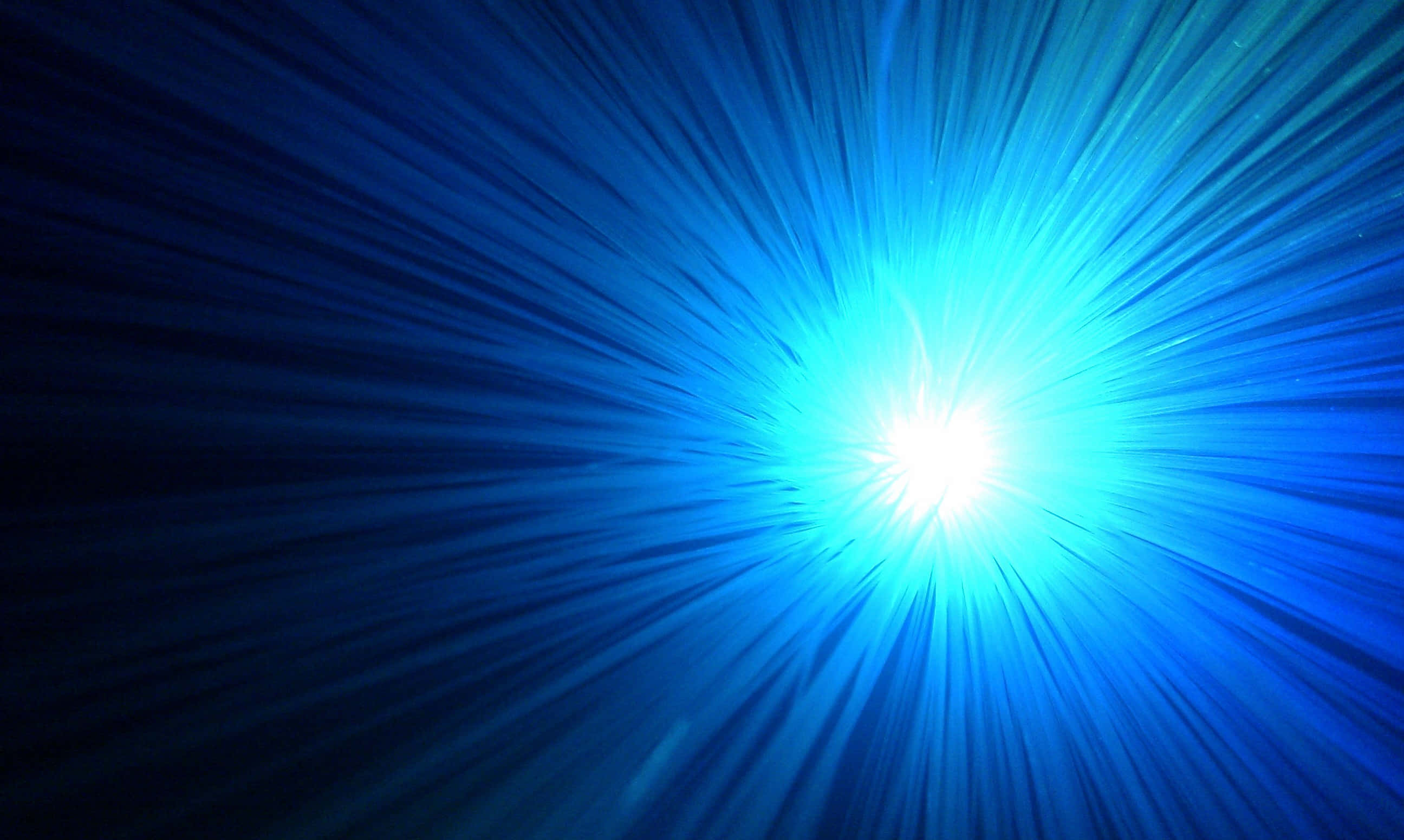 Bright 桌布 壁紙 — 一道耀眼的藍光在黑暗背景中迸發出銳利的光線，營造出宇宙隧道效果。