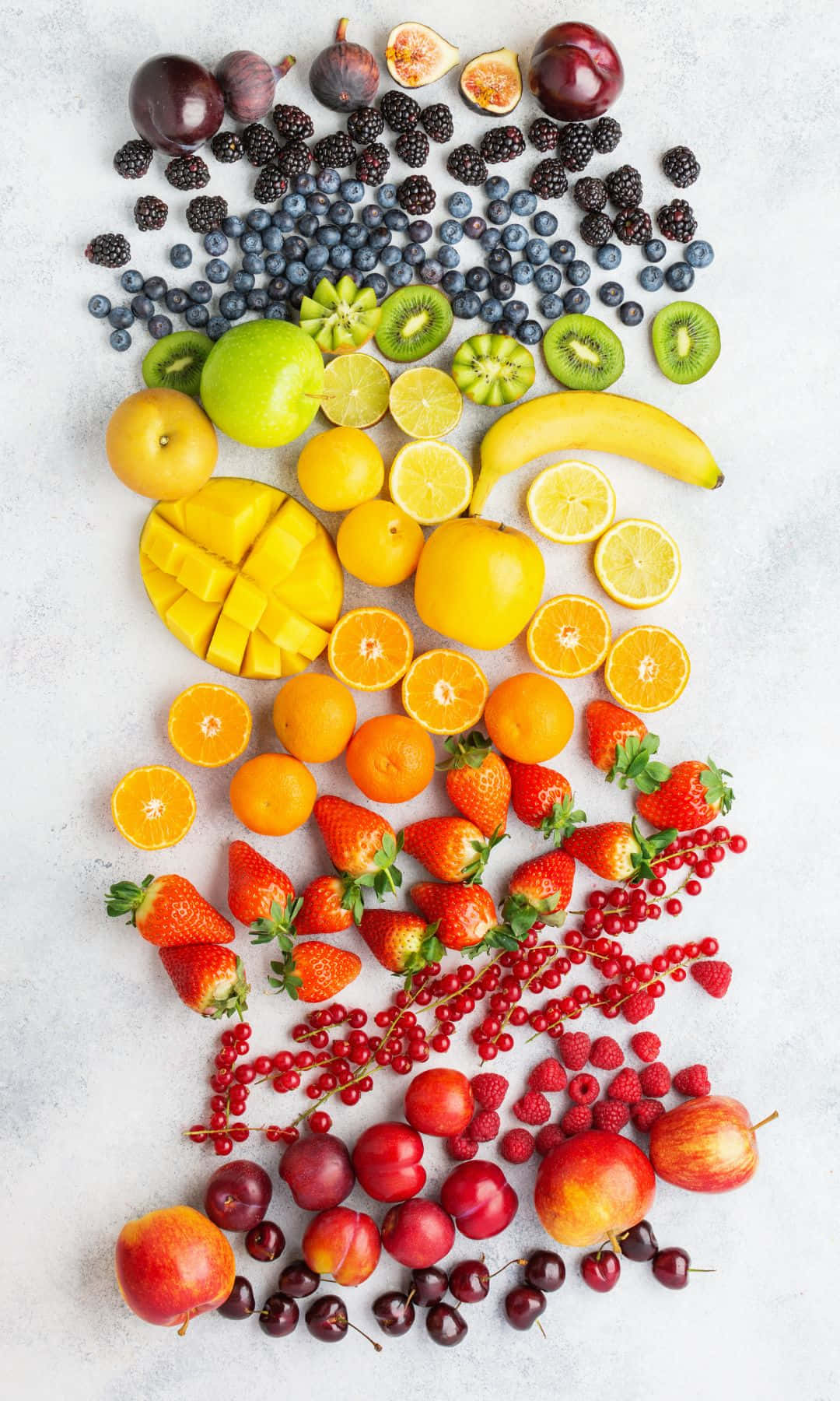 1080x1800 桌布 壁紙 — 一道色彩繽紛的新鮮水果彩虹，在淺灰色表面上以從紫色到紅色的顏色漸變藝術地排列。