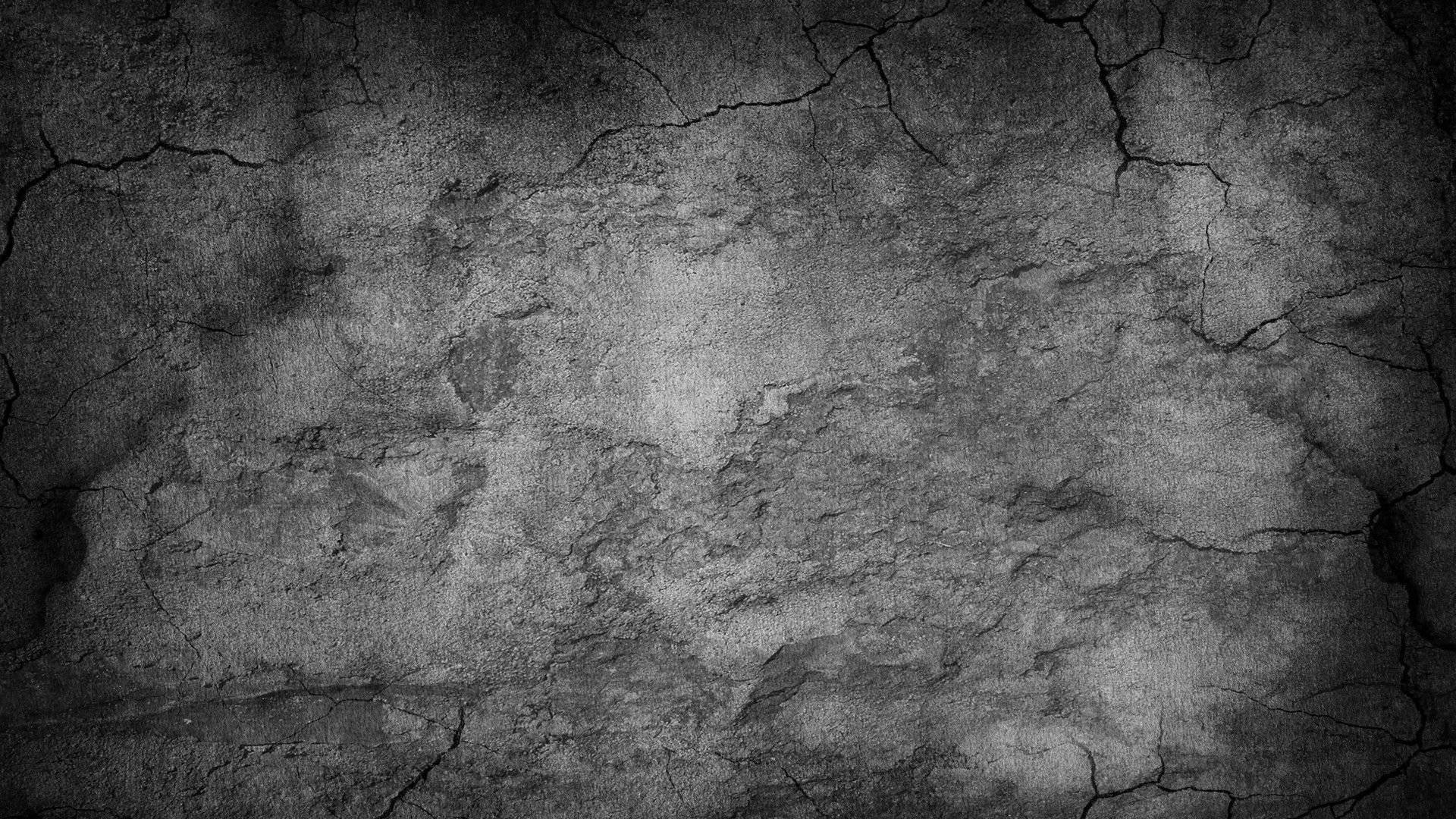 Concrete 桌布 壁紙 — 一道裂開的混凝土牆，帶有粗糙質感和深灰色調，在昏暗燈光下。