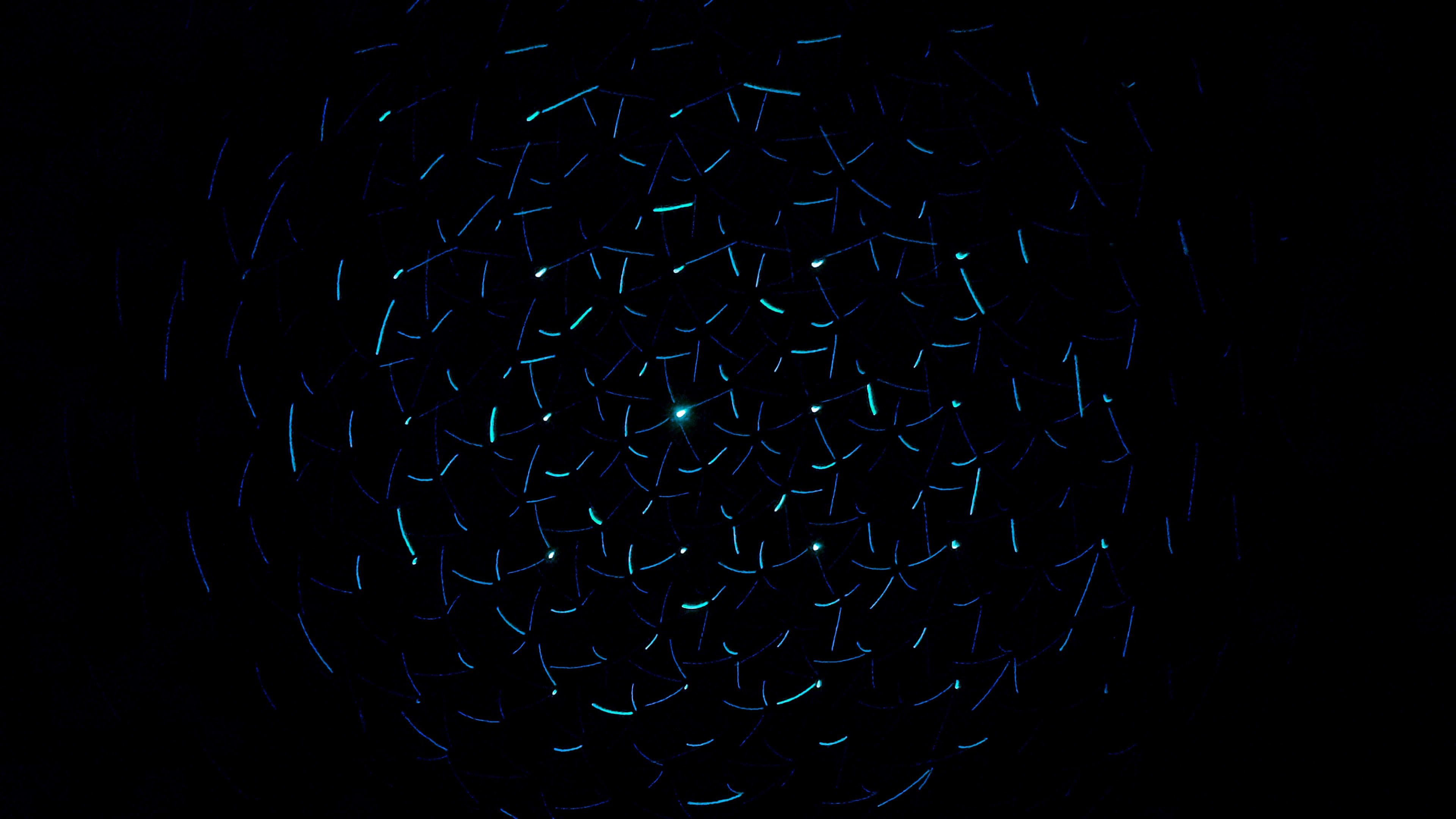 Glow In The Dark 桌布 壁紙 — 一道迷人的螺旋形發光藍色光跡在深邃的黑色虛空中向外輻射。
