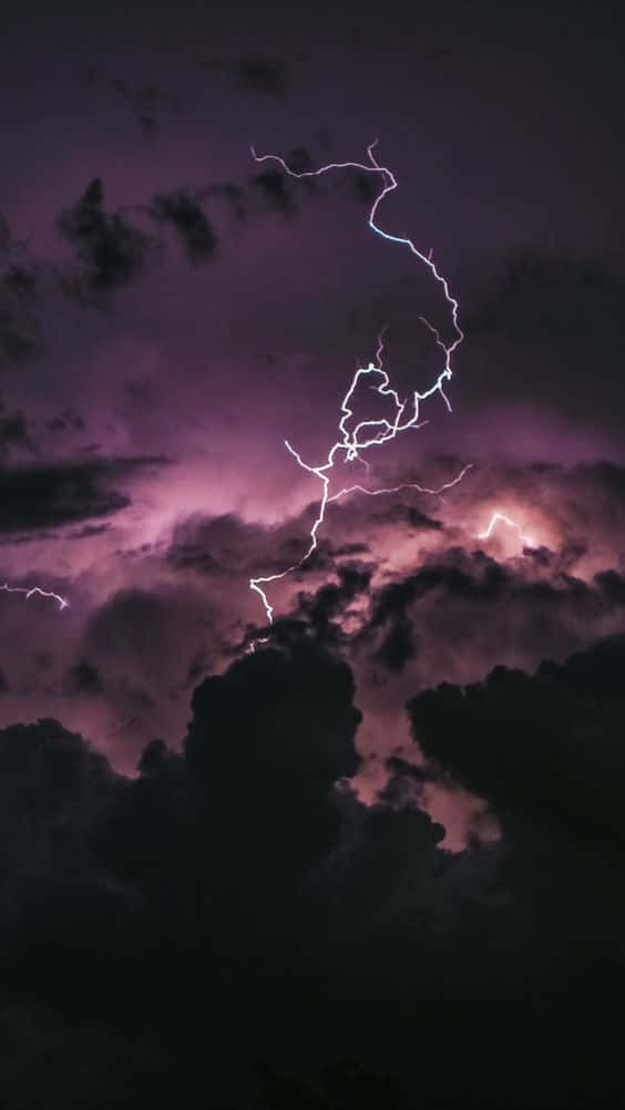 Dark Clouds 桌布 壁紙 — 一道鋸齒狀閃電劃破充滿烏雲的紫色暴風雨天空，形成分叉。