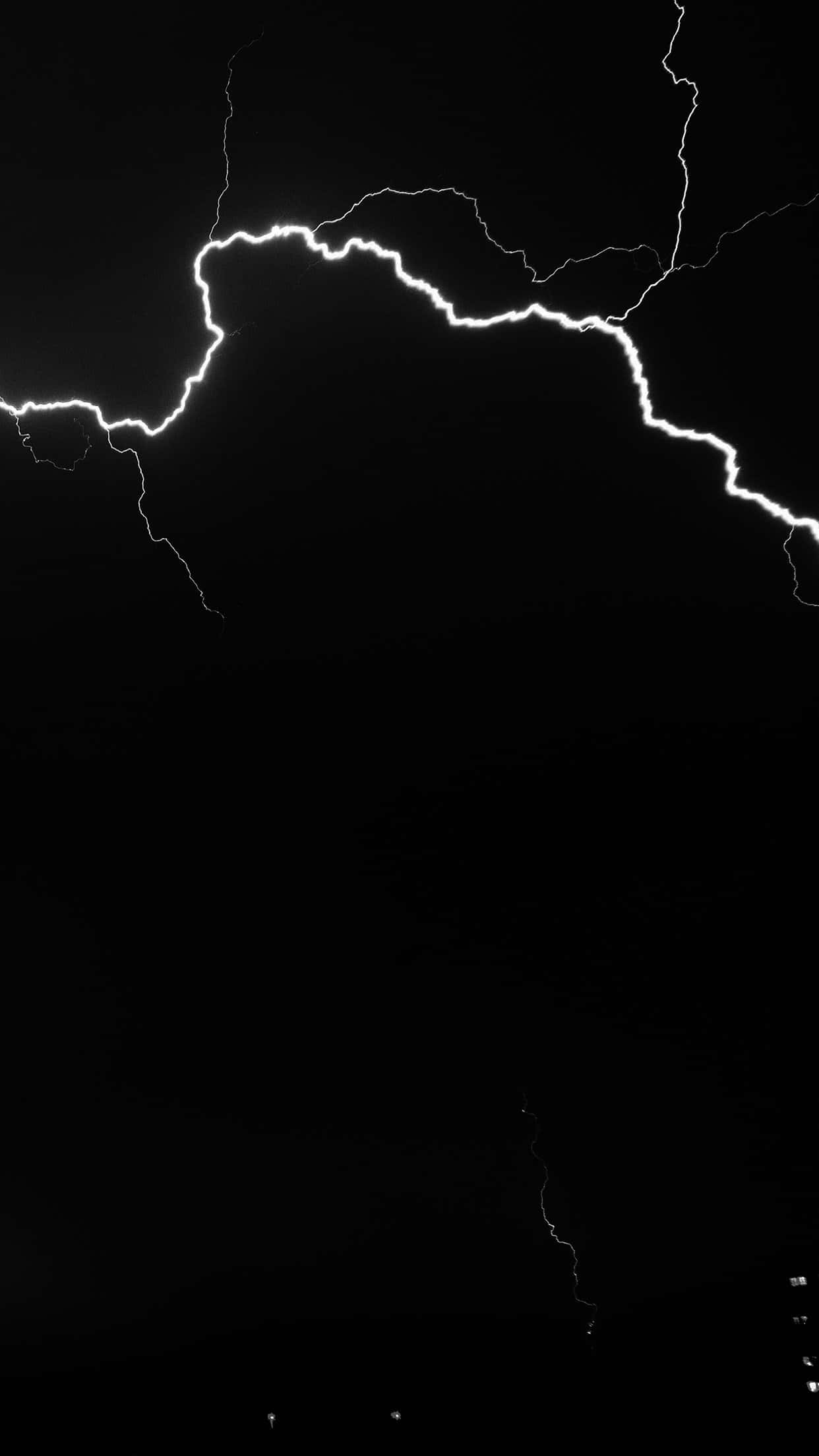 Black And White Storm 桌布 壁紙 — 一道鋸齒狀閃電在漆黑的天空中岔開，形成高對比度的黑白照片。