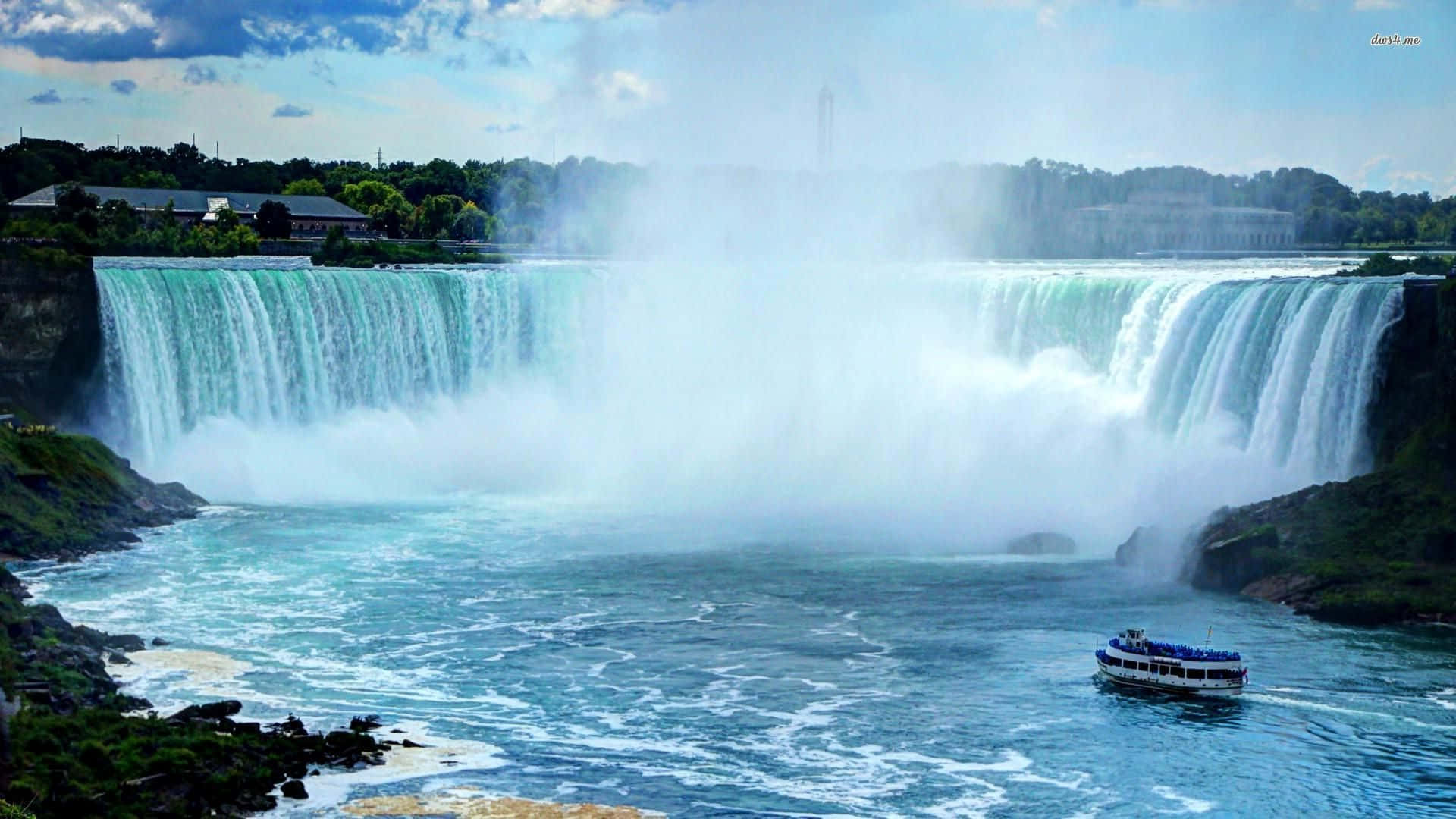 720p Niagara Falls 桌布 壁紙 — 一道雄偉寬闊的瀑布傾瀉而下，流入湍急的河流，一艘觀光船在部分多雲的天空下航行於霧氣瀰漫的水域。